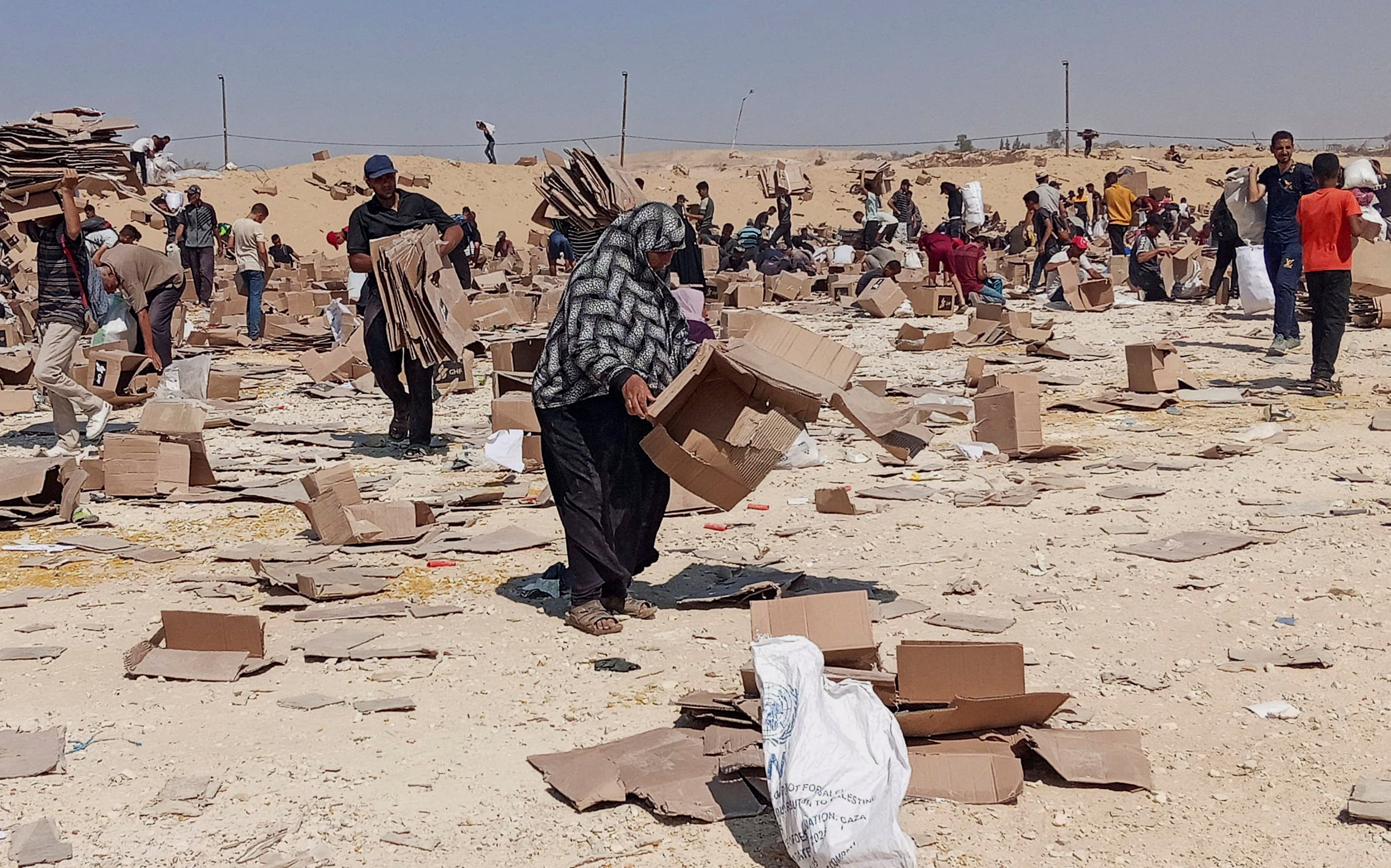 Palestinians gather to collect what remains of relief supplies from the Gaza Humanitarian Foundation, distribution centre in Rafah on Saturday. Photo: Reuters
