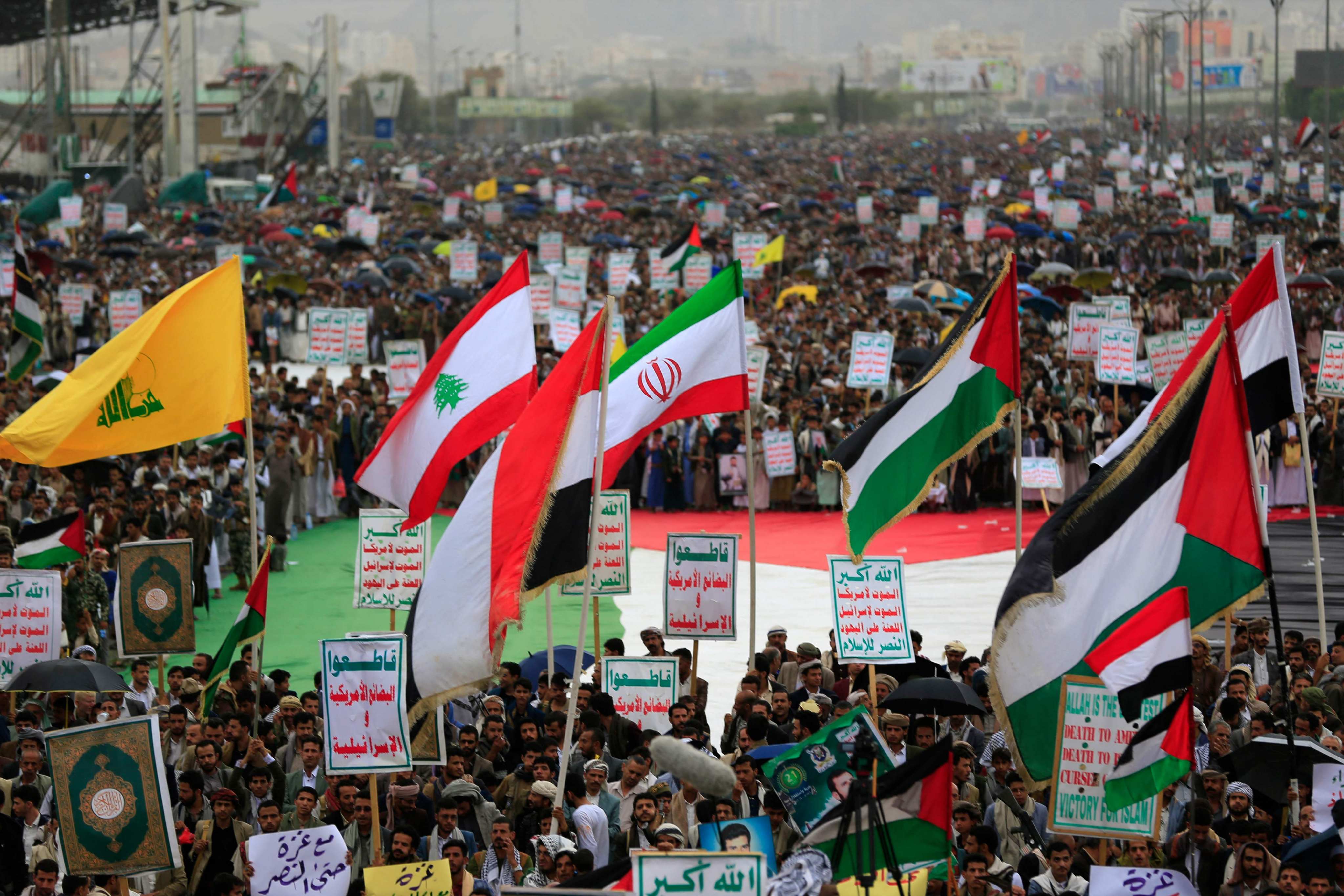 Yemenis wave the flags of Hezbollah, Lebanon, Iran and Palestine during a rally in the Houthi-run capital Sanaa on Friday. On Sunday, the Israeli military said it would strike the Yemeni ports of Hodeidah, Ras Isa and Al-Salif. Photo: AFP