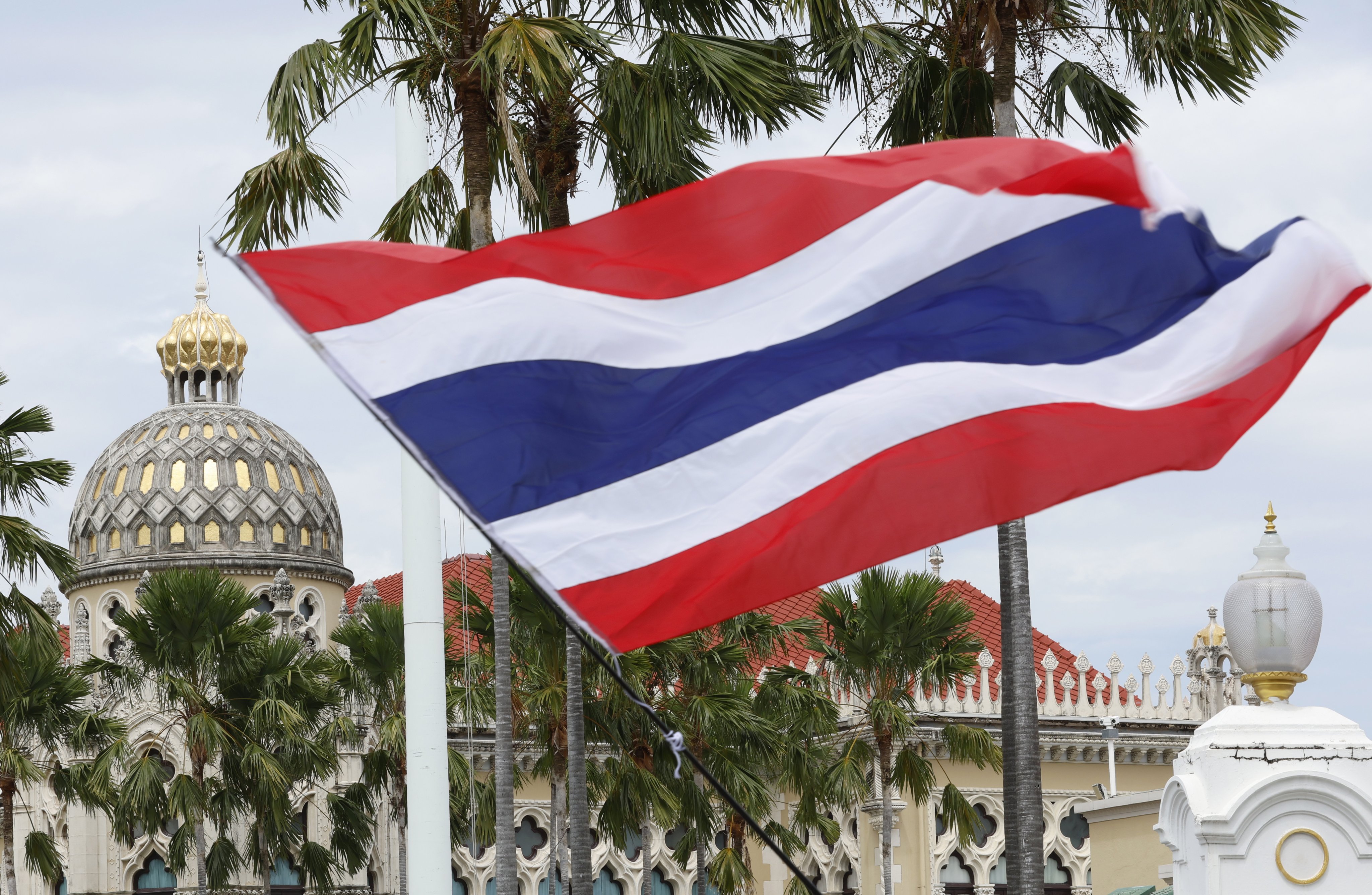 A protester waves Thailand’s national flag outside Government House in Bangkok last month during a rally calling for the resignation of the now-suspended prime minister, Paetongtarn Shinawatra. Photo: EPA