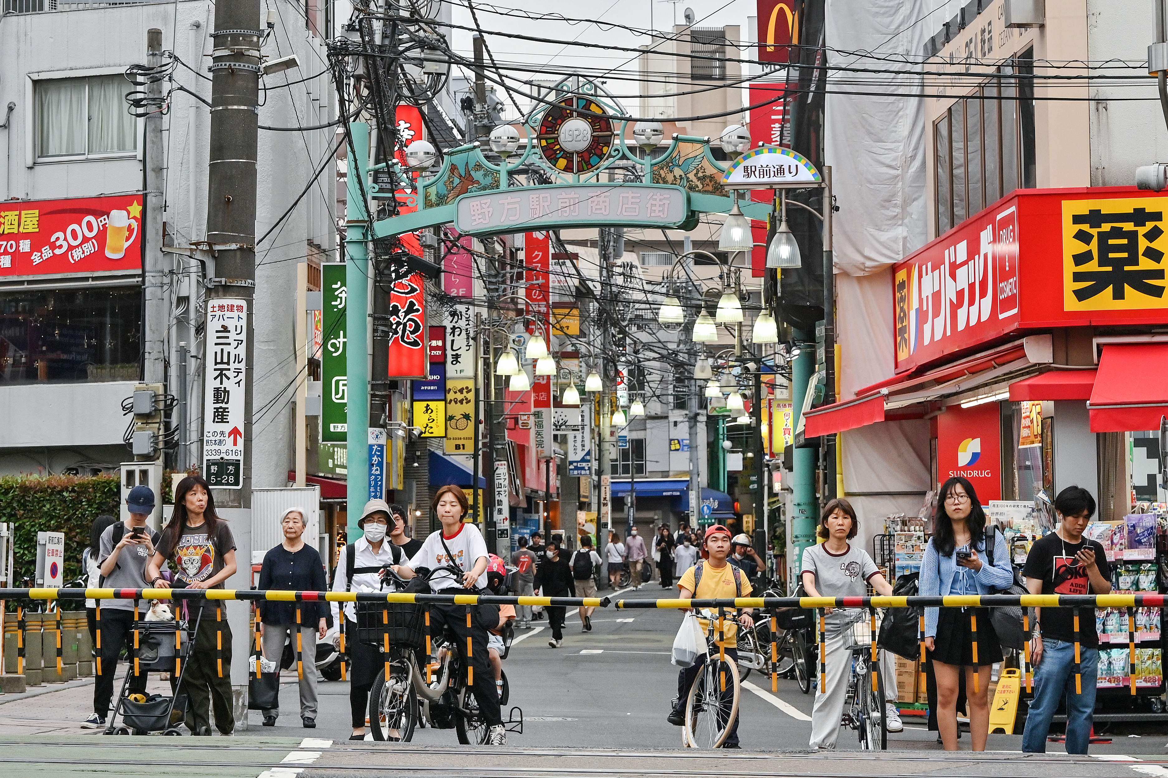 People wait at a level crossing along a shopping street in the Nakano ward of Tokyo. Real wages declined 2.9 per cent from a year earlier in May, Japan’s labour ministry reported on Monday. Photo: AFP