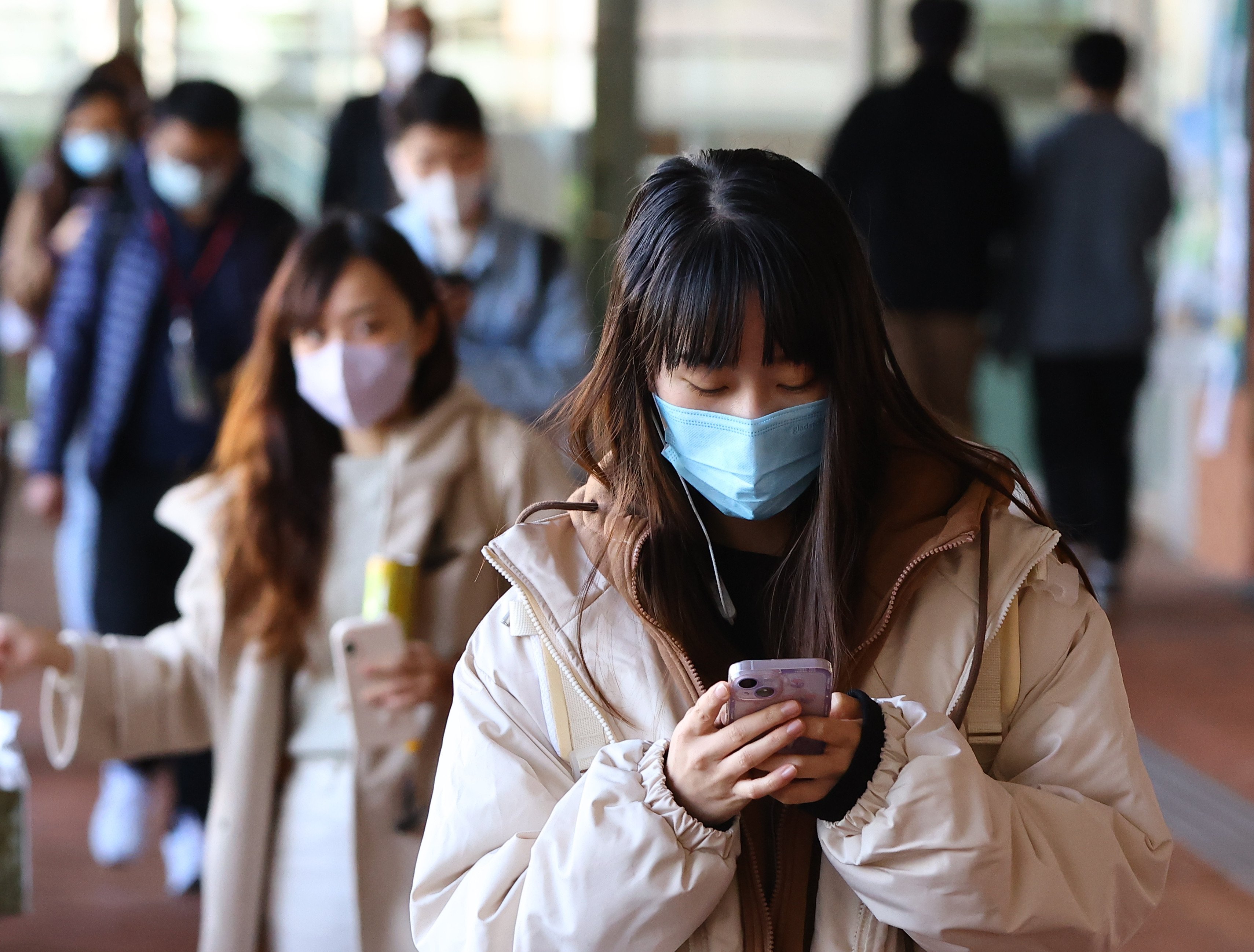 A student checks her phone as she walks through the campus of the University of Hong Kong in 2022. Photo: Dickson Lee