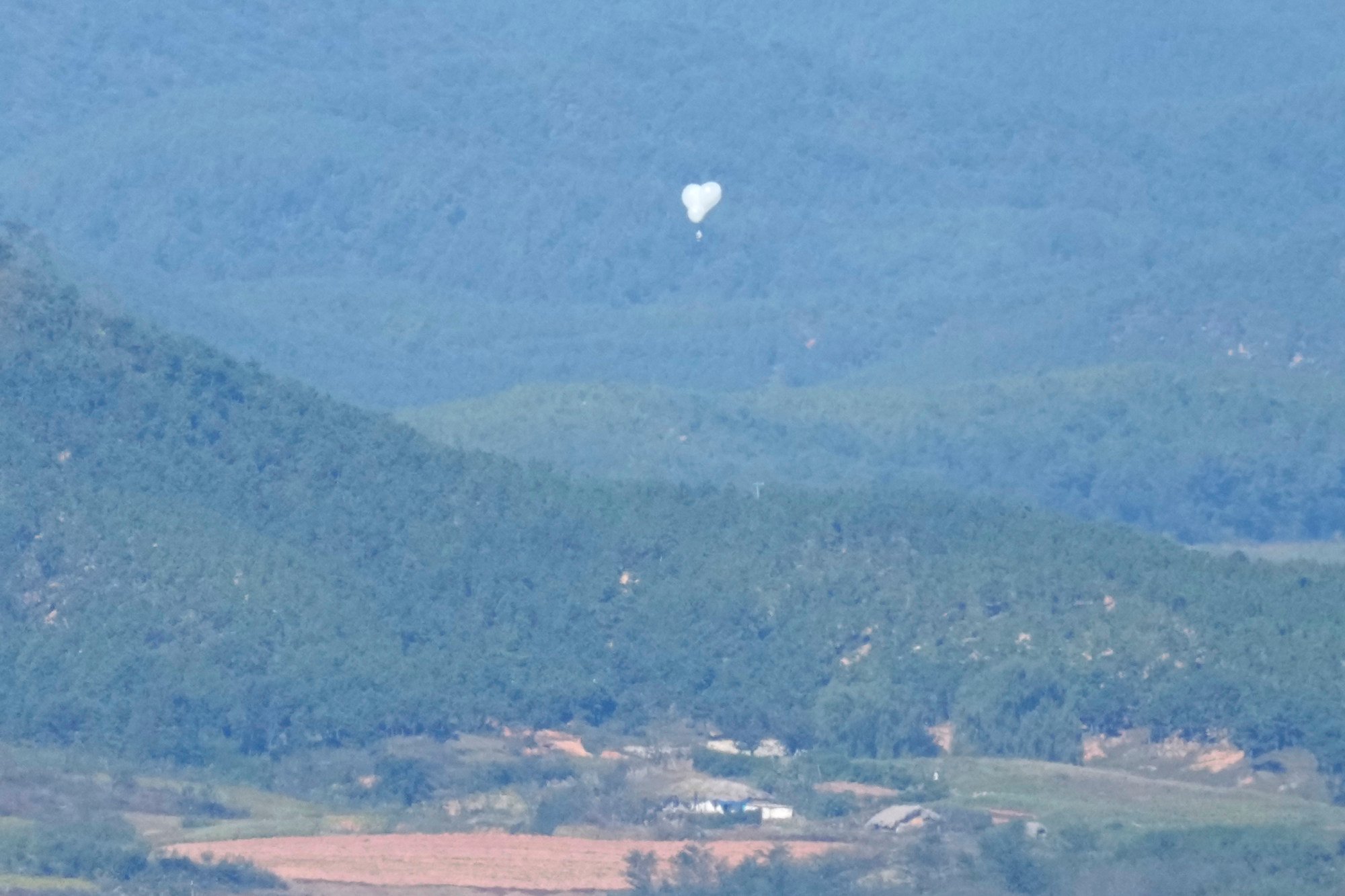 Balloons from North Korea float over the demilitarized zone that separates the two Koreas as seen from an observation post in Paju, South Korea, on October 4. Photo: AP Balloons from North Korea float over the demilitarized zone that separates the two Koreas as seen from an observation post in Paju, South Korea, on October 4. Photo: AP