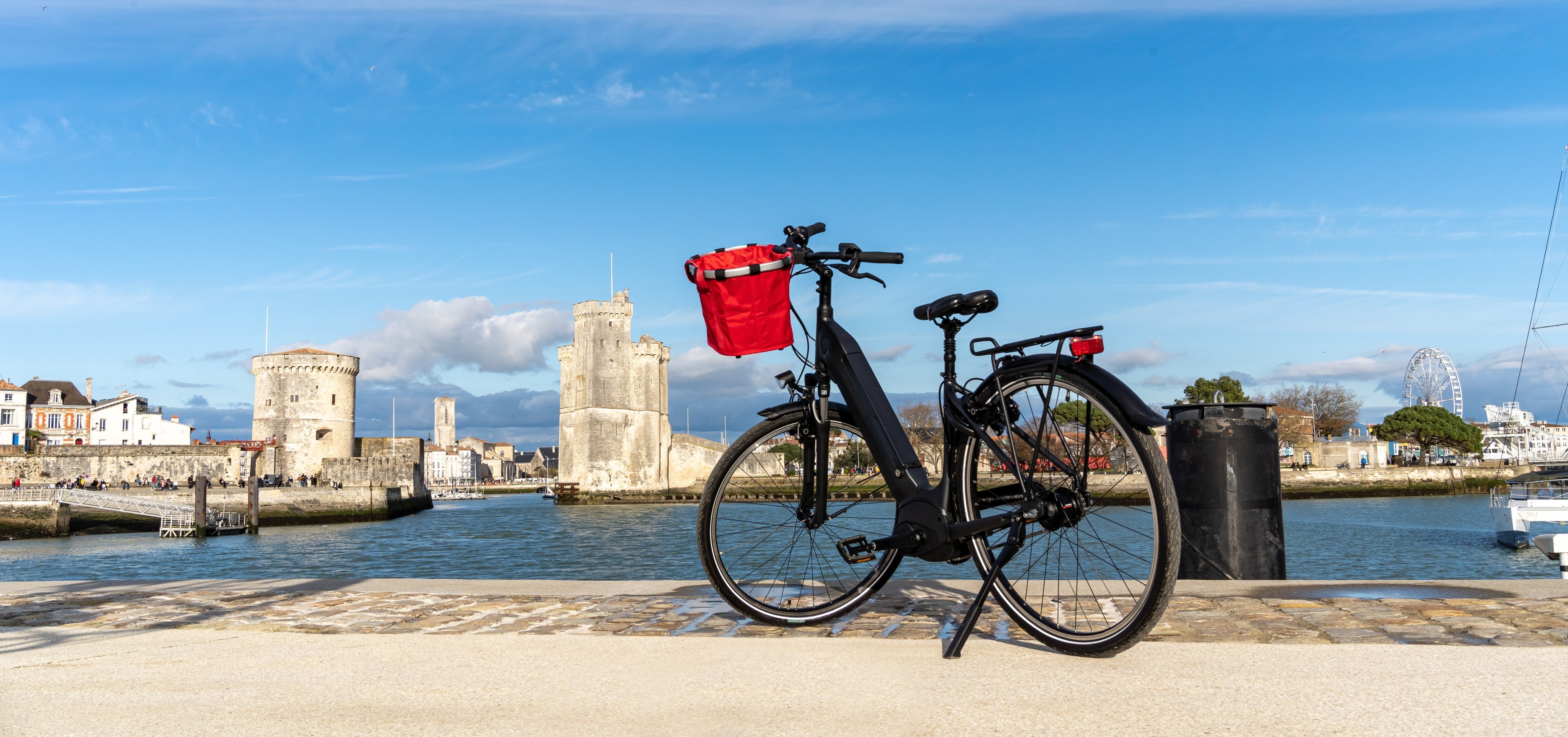 La Rochelle old harbor. Rear view of a bicycle looking at city view while standing on observation point.
