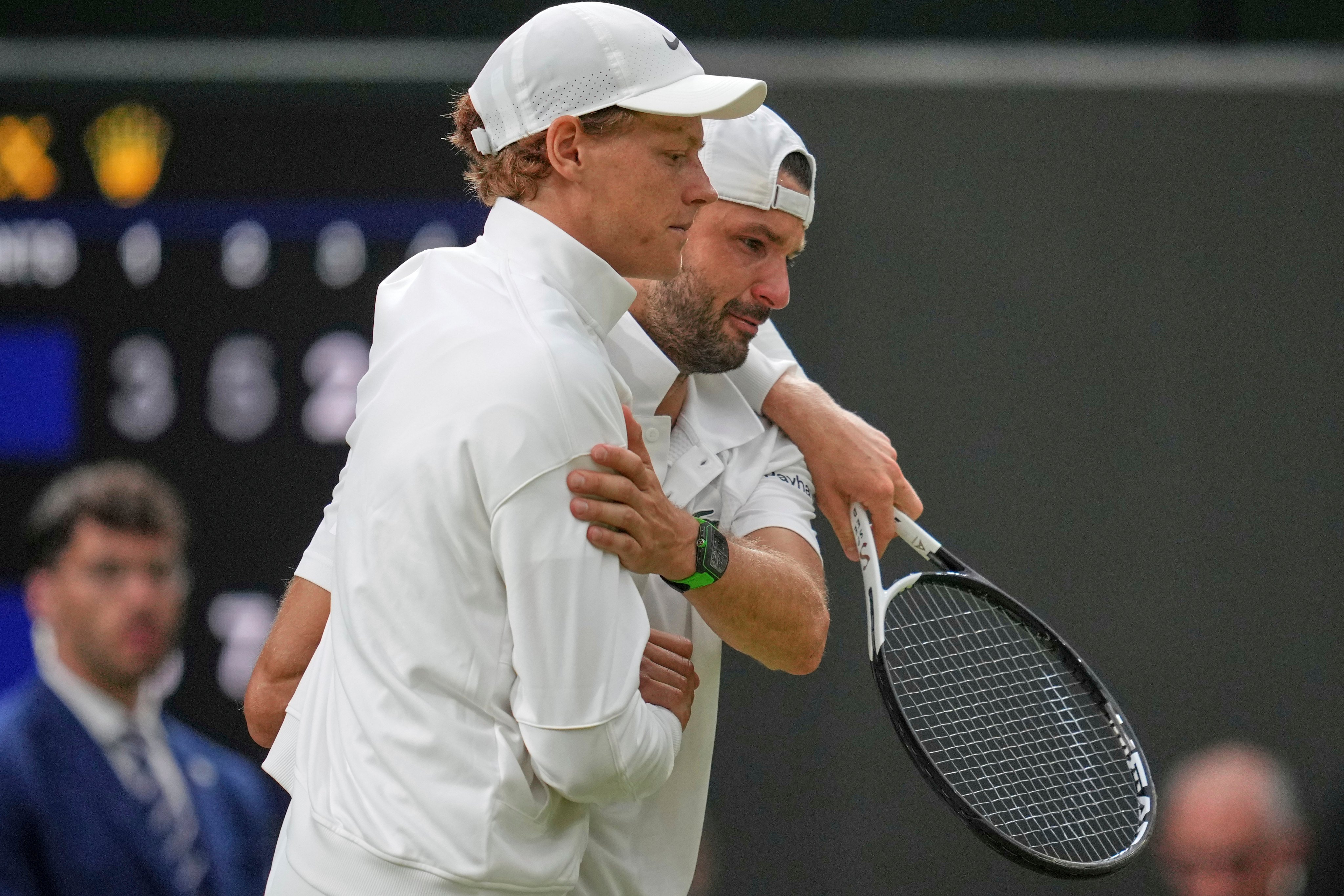 Jannik Sinner (left) helps a tearful Grigor Dimitrov off the court at Wimbledon. Photo: AP