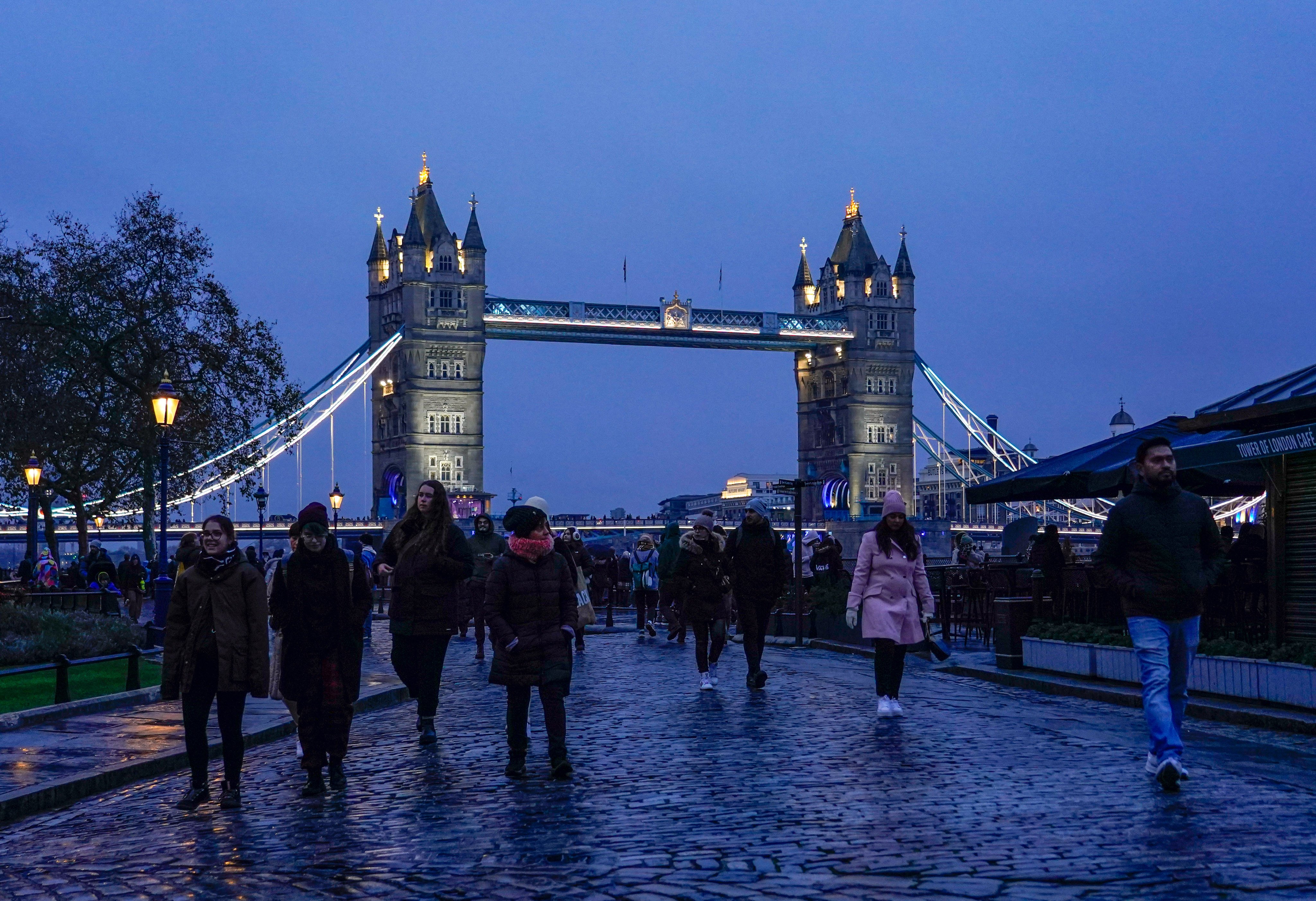 People walk outside the Tower of London as the Tower Bridge stands on the river Thames. Photo: AP