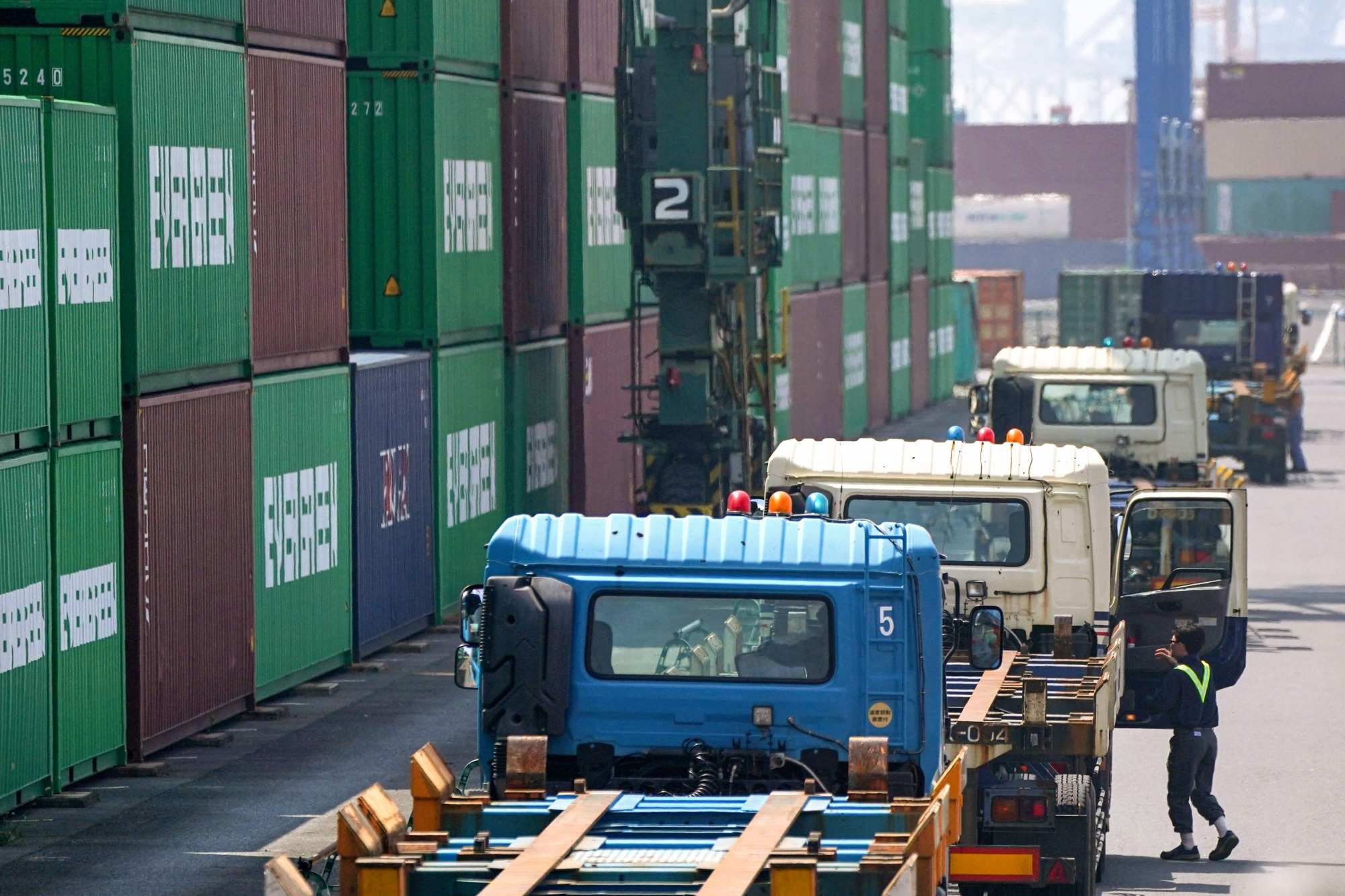 Trucks waiting to load containers at the international cargo terminal at the port of Tokyo on Tuesday. Photo: AFP