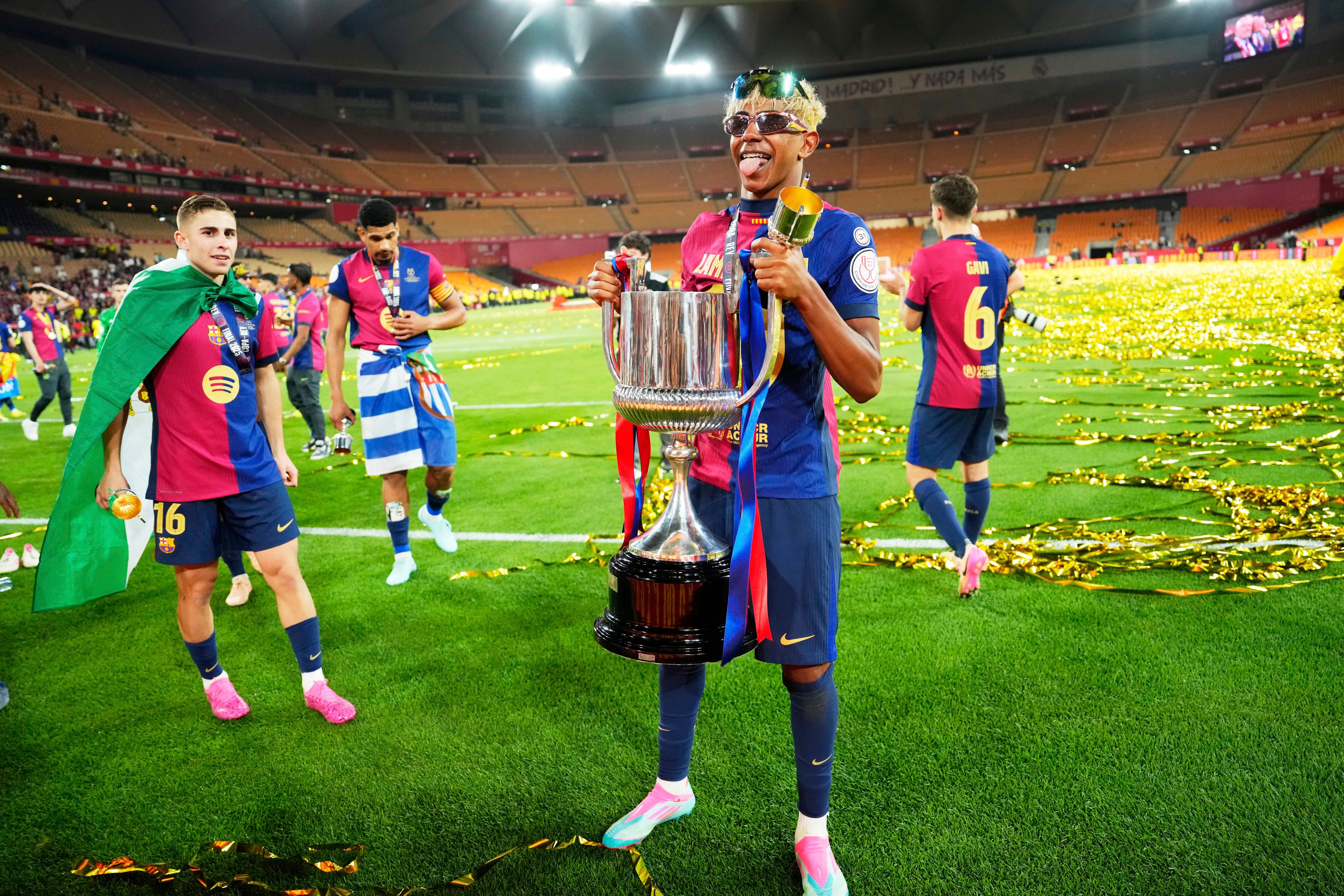 Barcelona’s Lamine Yamal holds the Spanish Cup trophy following victory over Real Madrid in April. Photo: AP