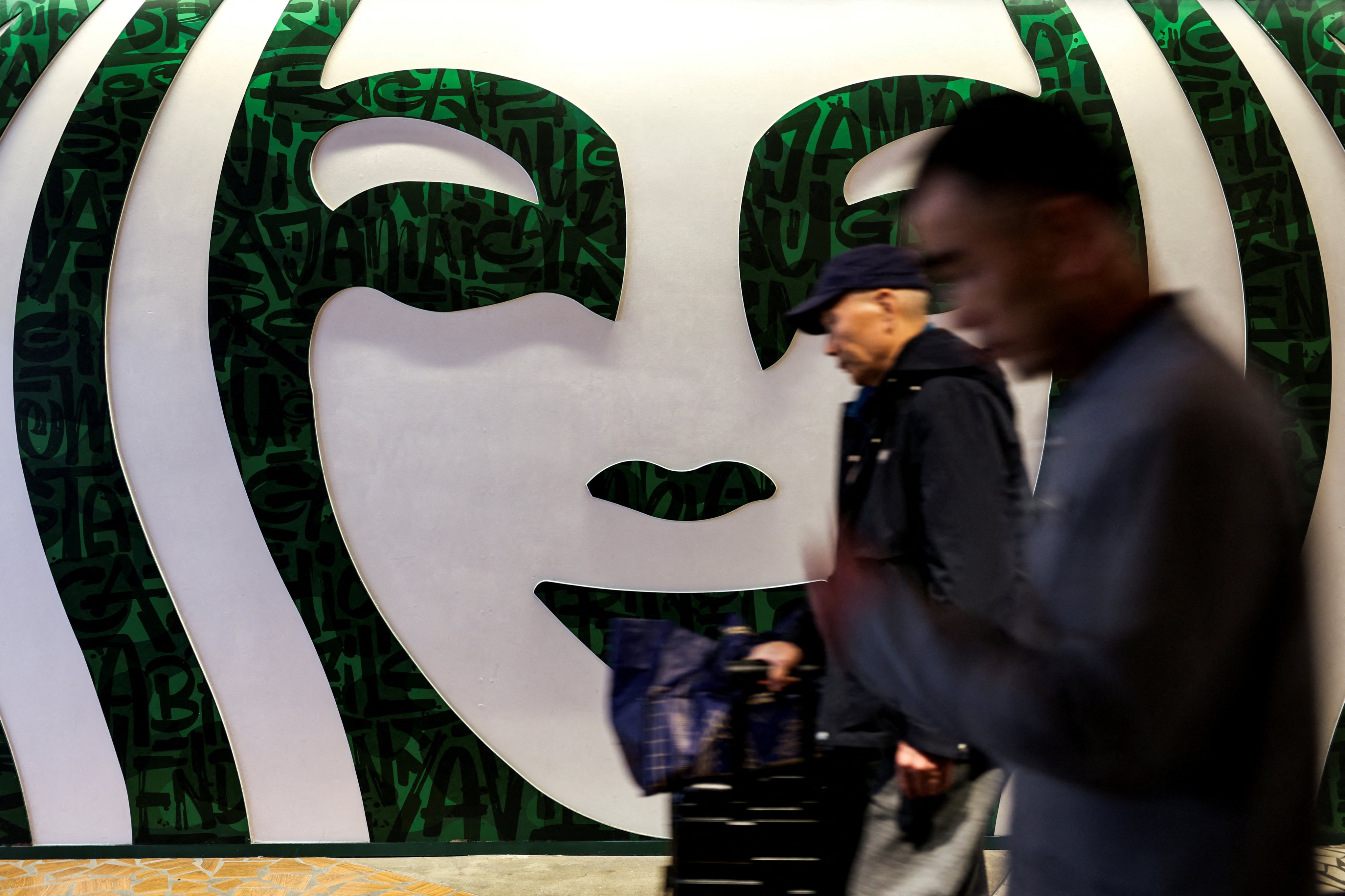 People walk past a large Starbucks logo in Shanghai, on February 28, 2025. Photo: Reuters