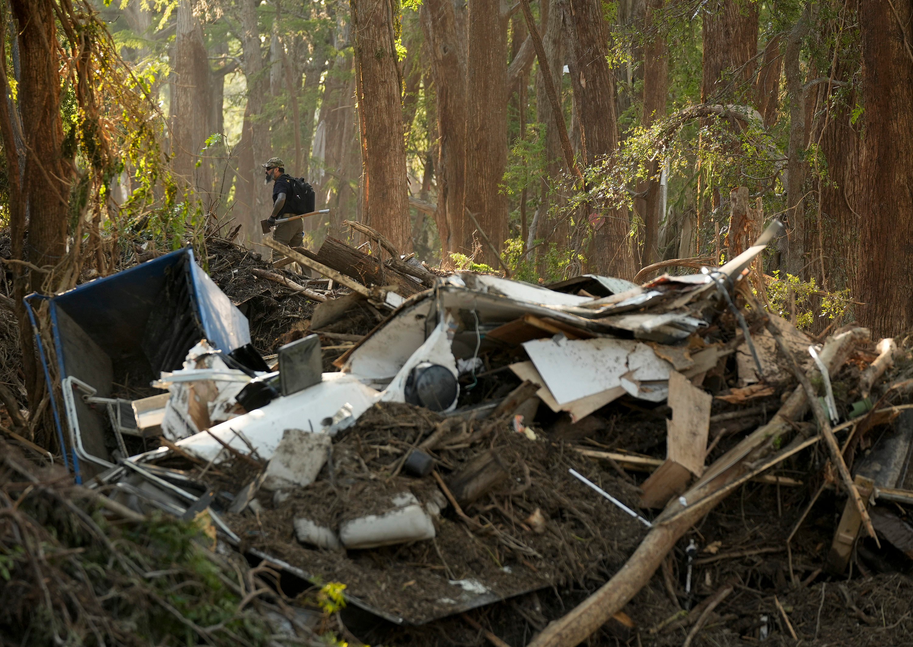 A  volunteer searches on the banks of the Guadalupe River in Ingram, Texas. Photo: Austin American-Statesman via AP