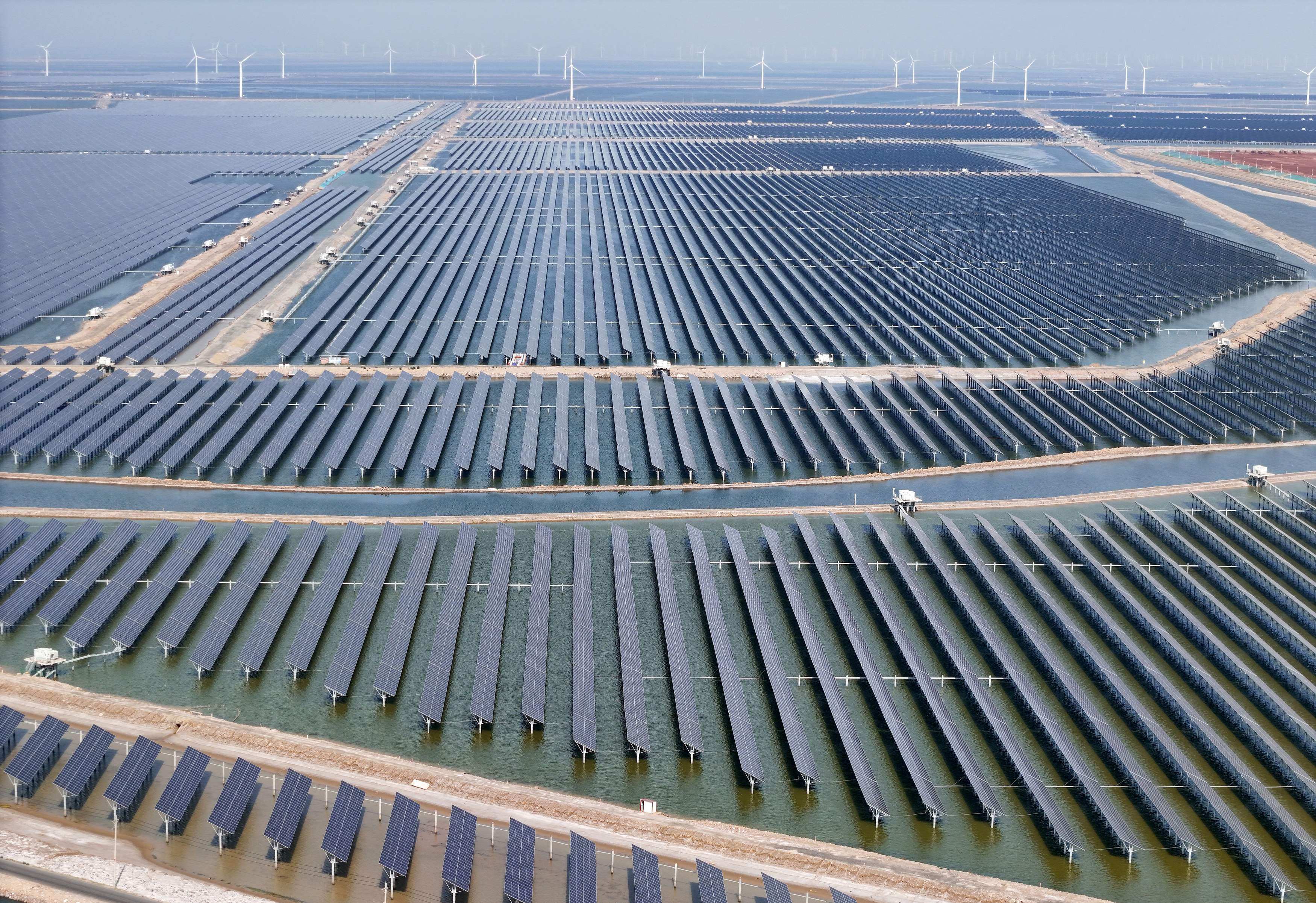 Solar panels and wind turbines are seen at the Huaneng Binzhou new energy power generation project in Binzhou, in Chinas eastern Shandong province, on June 11, 2025. Photo: AFP