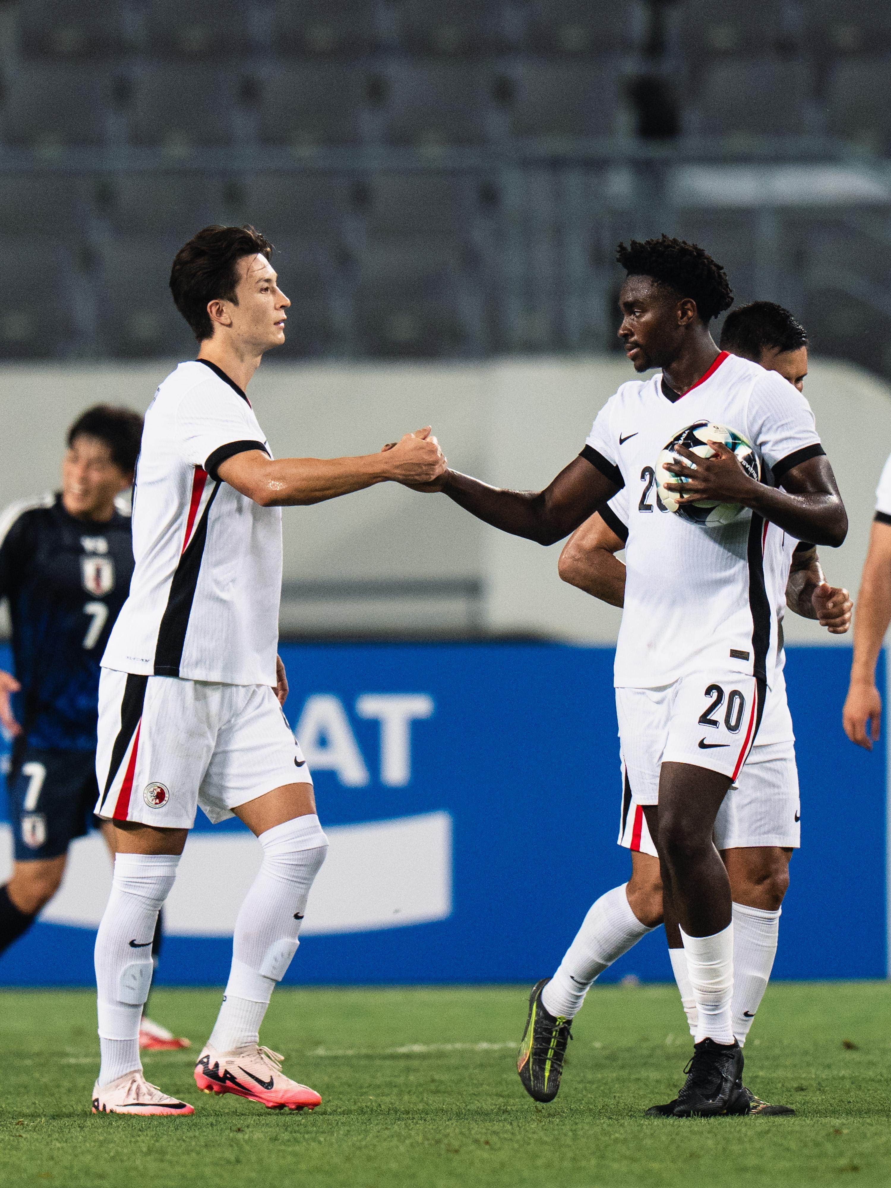 Michael Udebuluzor congratulates fellow striker Matt Orr on his goal against Japan. Photo: HKFA