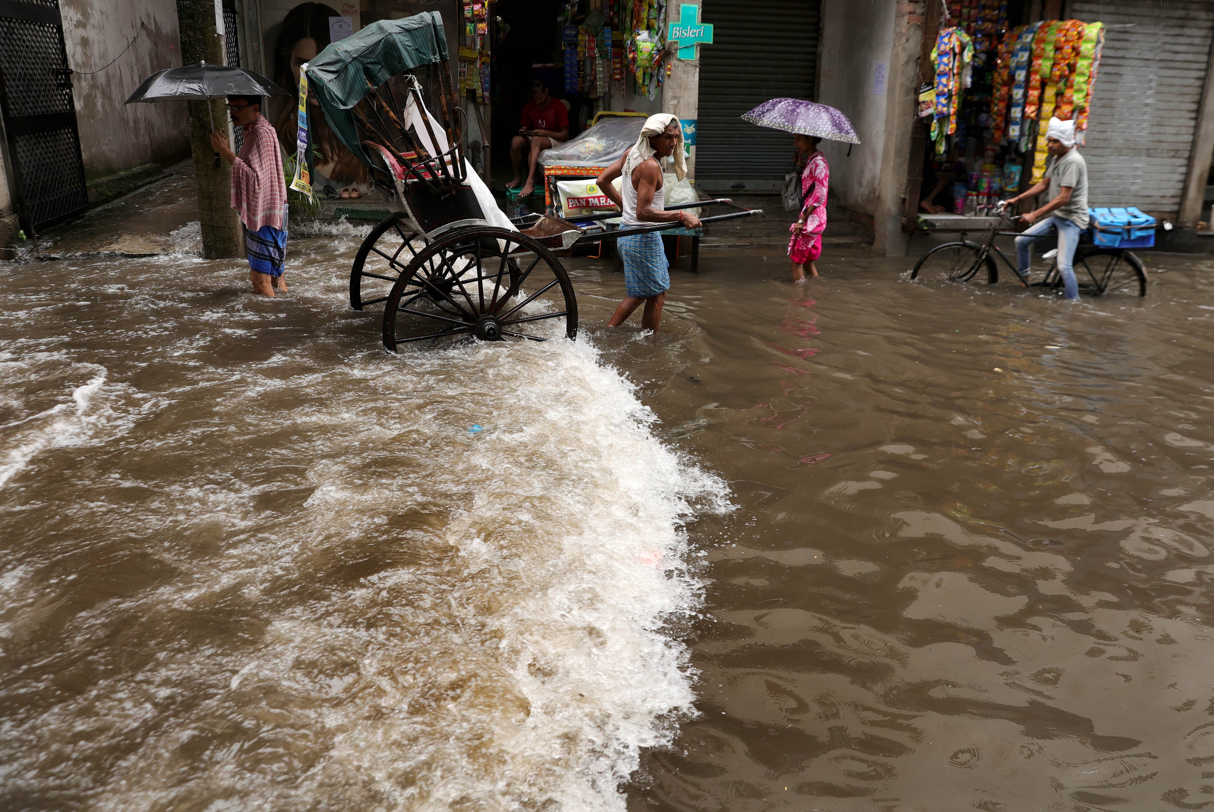 People make their way through a waterlogged street during heavy rain in Kolkata, India, on July Tuesday. Photo: EPA