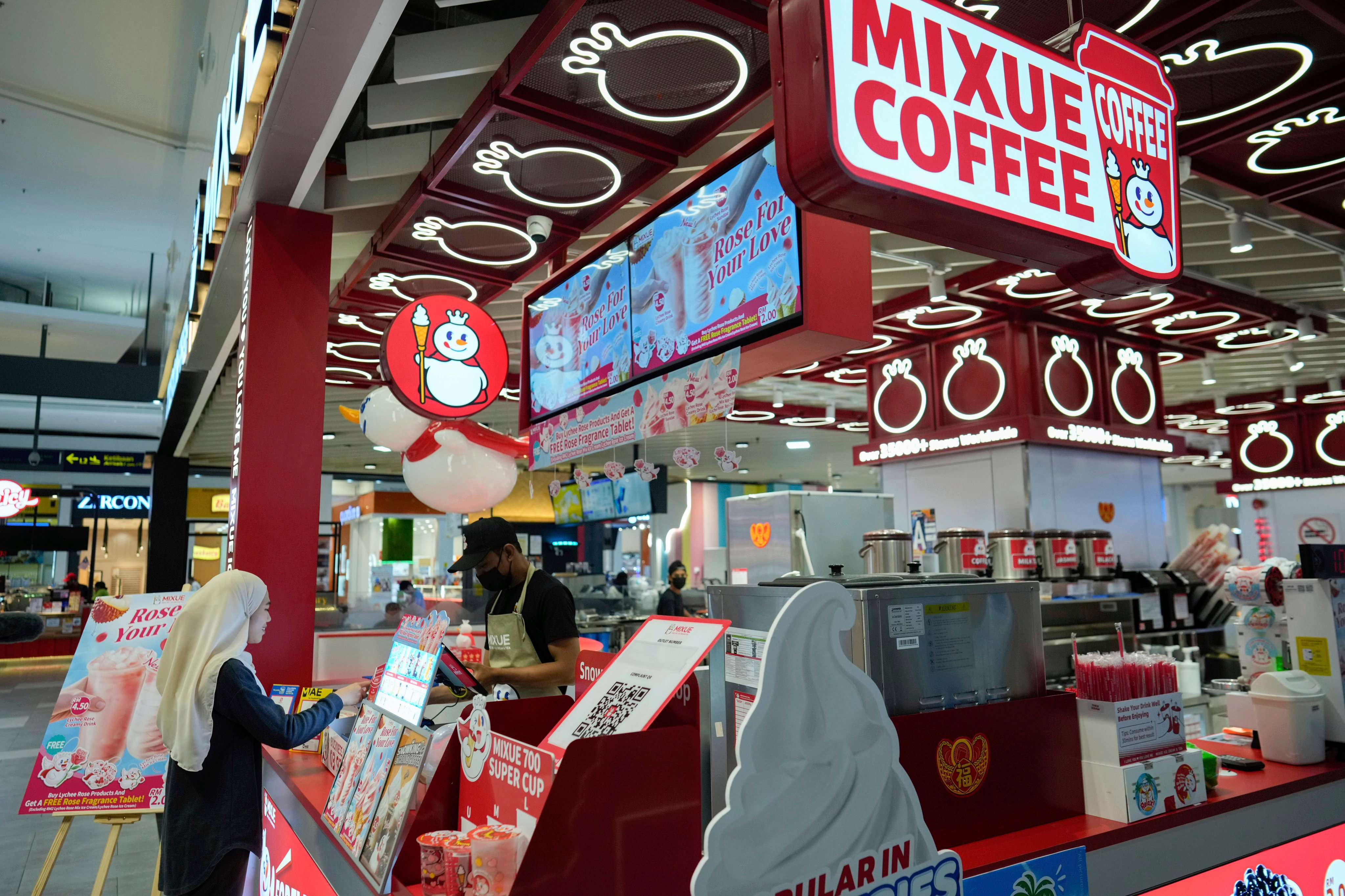 A woman buys a drink from Mixue outlet at a shopping centre in Sepang, Malaysia. Photo: AP