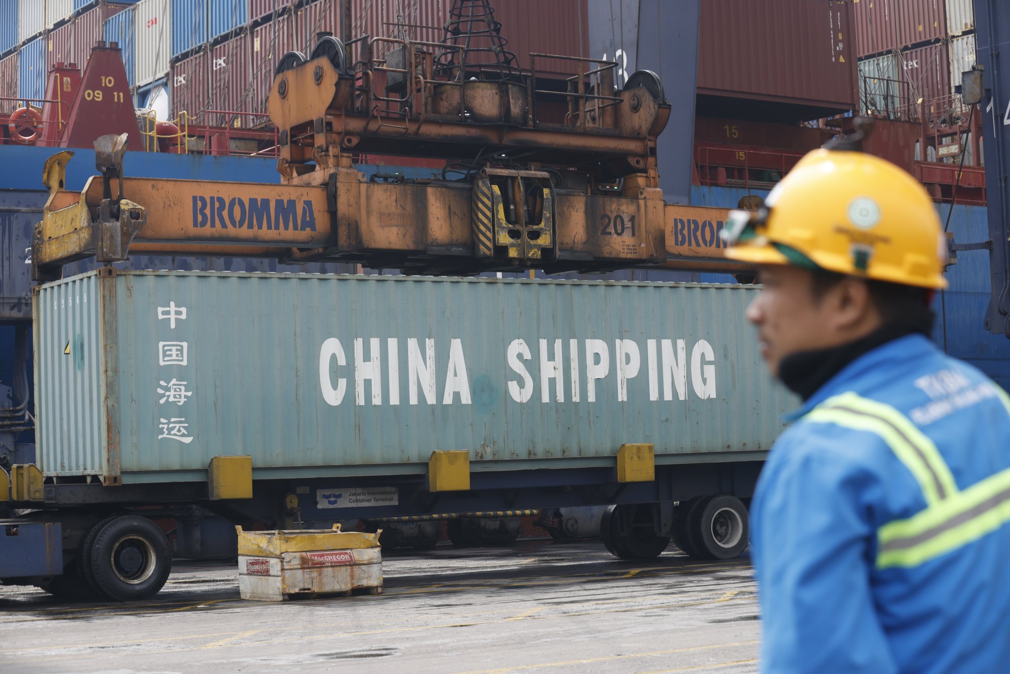 An Indonesian worker watches containers being loaded onto trucks at the Jakarta International Container Terminal, at Tanjung Priok Port on July 9. Photo: EPA An Indonesian worker watches containers being loaded onto trucks at the Jakarta International Container Terminal, at Tanjung Priok Port on July 9. Photo: EPA