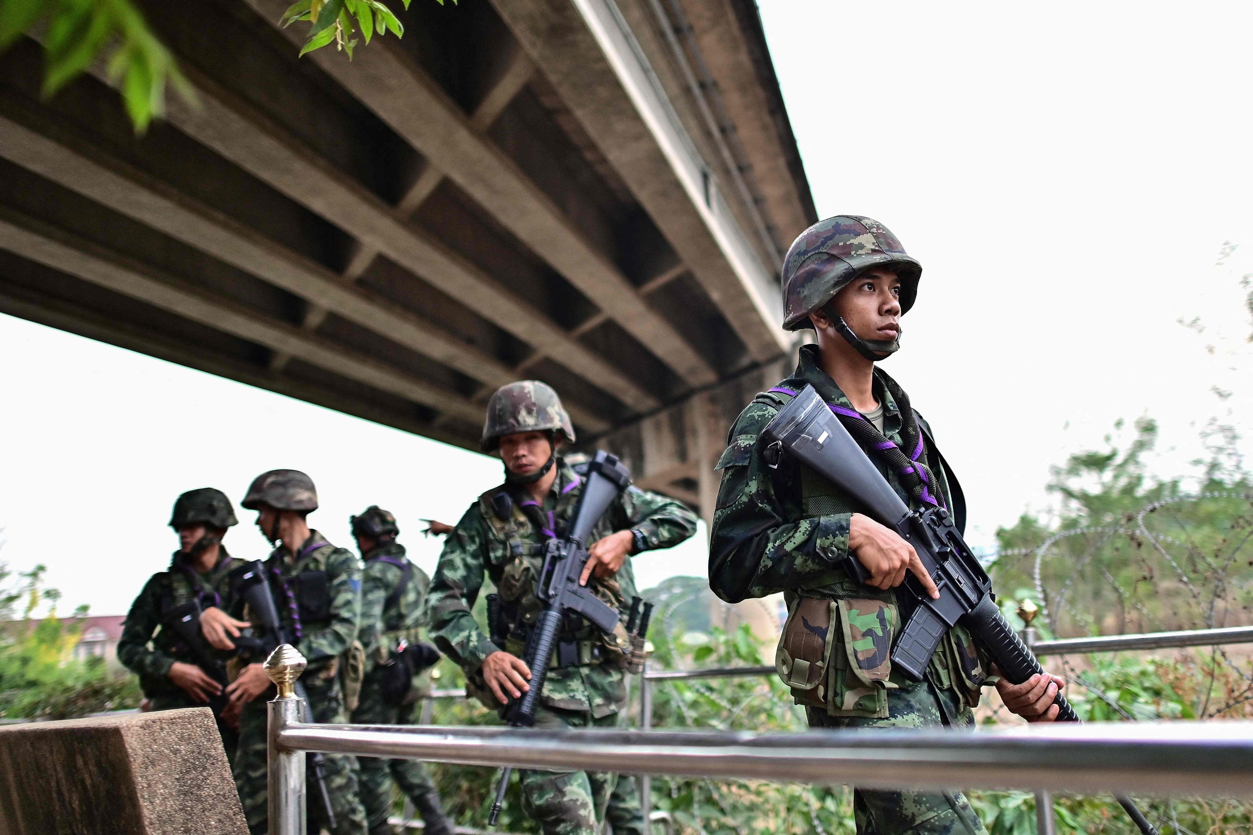 Thai soldiers stand guard overlooking the Moei river on the Thai side near the Tak border checkpoint in April 2024. More than 500 civilians and soldiers fled conflict in Myanmar and crossed into Thailand on Saturday.
