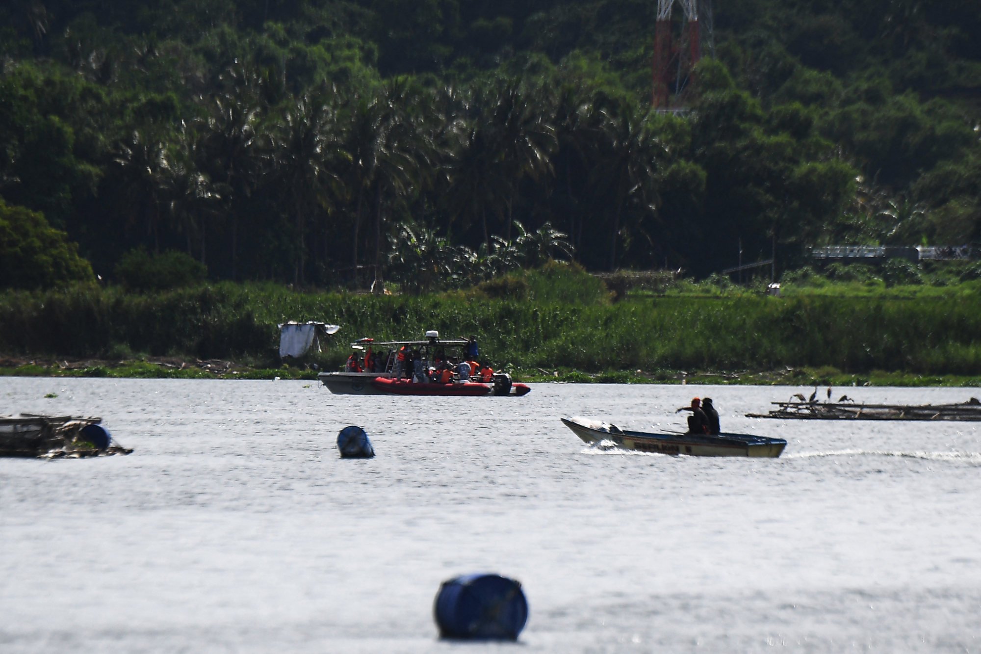 Philippine coastguard personnel aboard their boats arrive at the site where the bodies of cock fighters were allegedly dumped in Taal Lake on Thursday. Photo: AFP