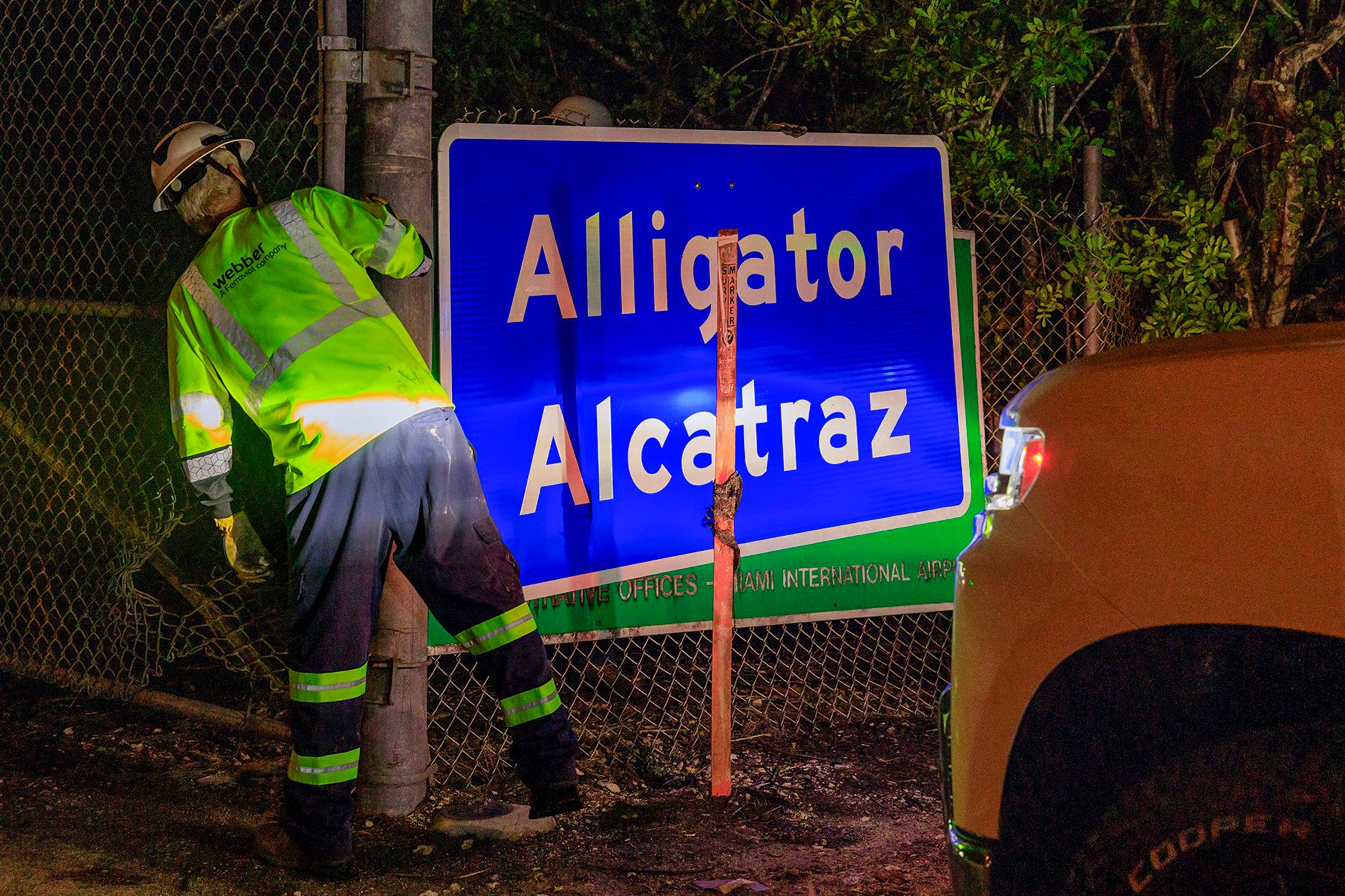 Two workers put up an “Alligator Alcatraz” sign at the entrance of the migrant detention centre in Ochopee, Florida, on July 2. Photo: TNS