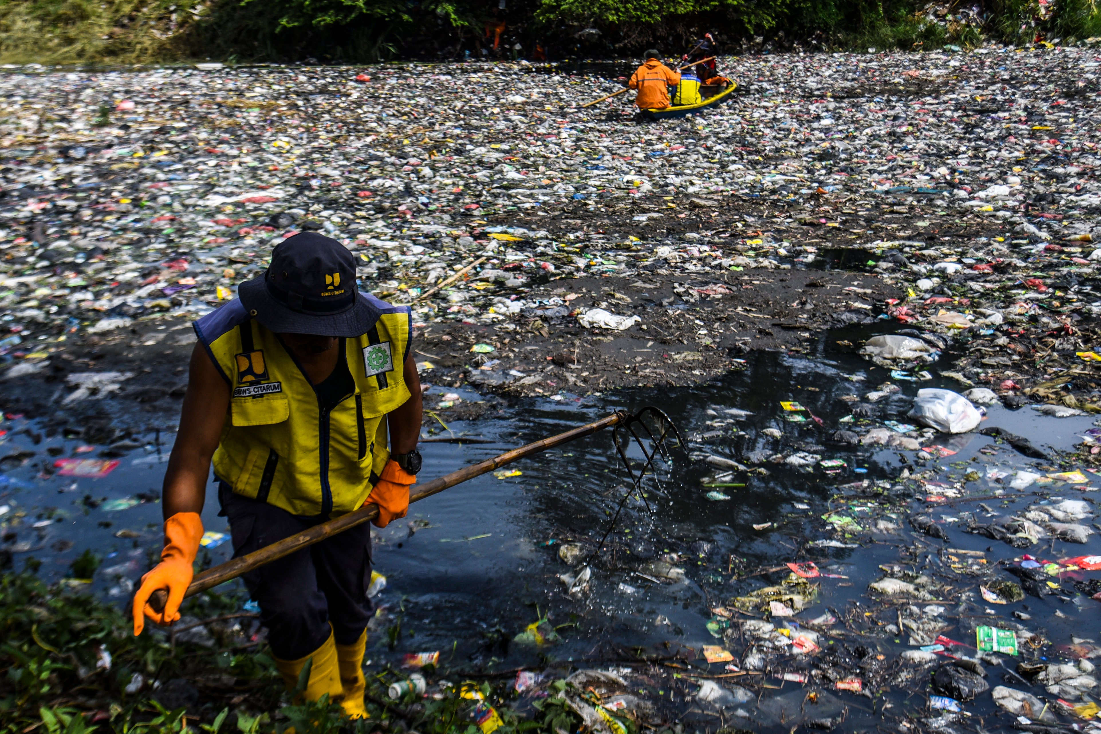 Moving rubbish in Java’s Citarum River which is clogged with plastic. Photo: dpa