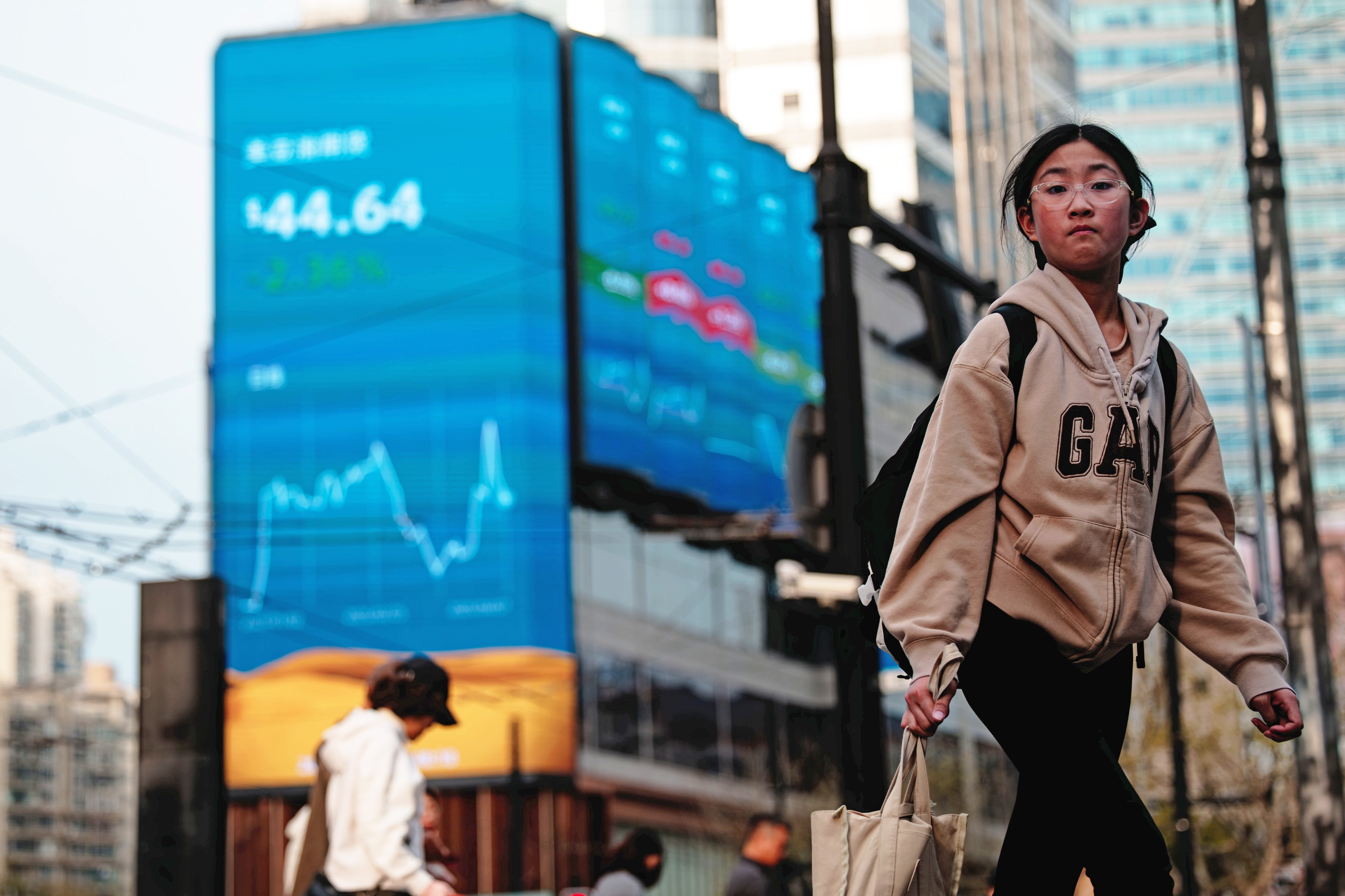 People pass stock screens in Shanghai. Photo: EPA-EFE