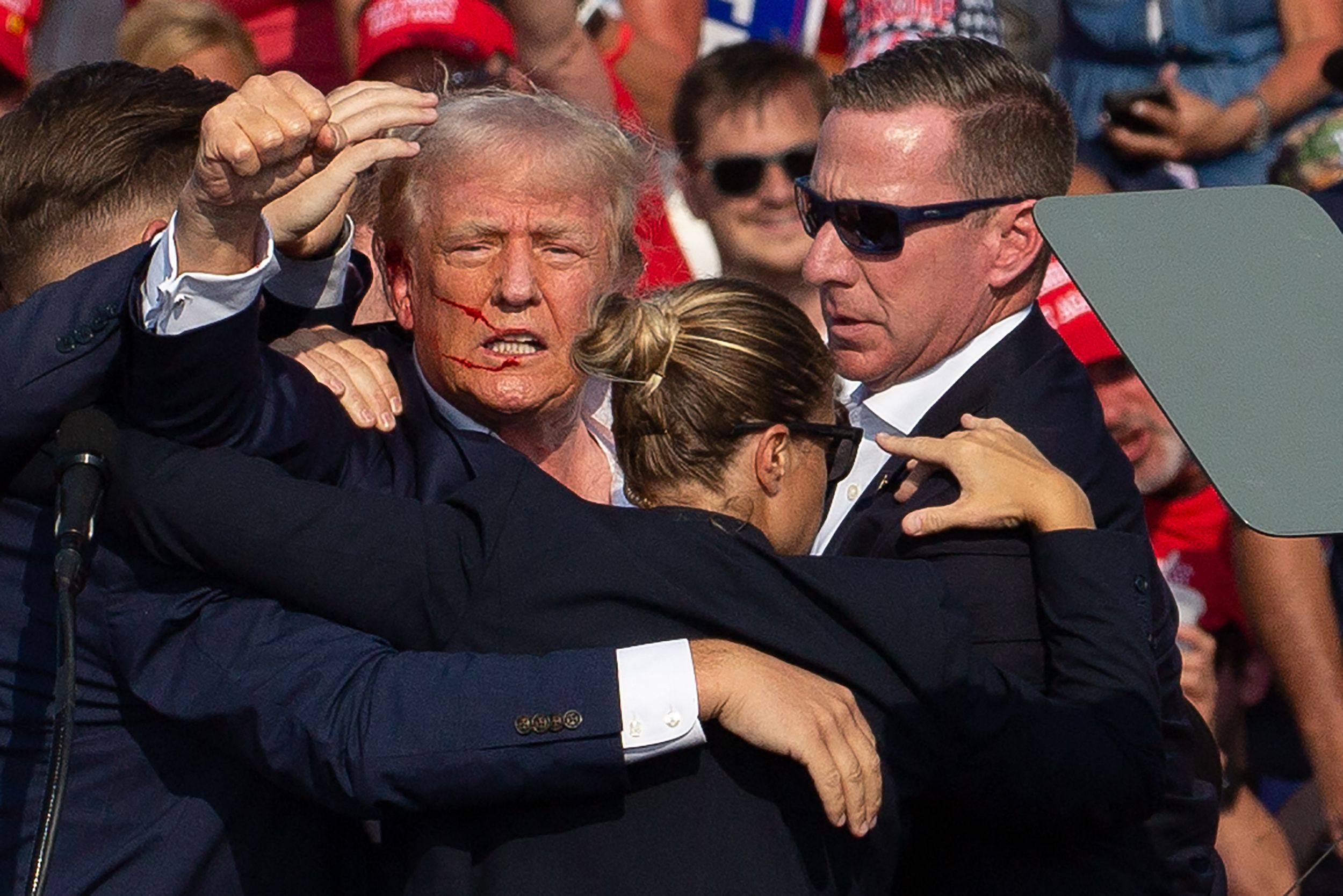Then-US Republican presidential candidate Donald Trump with blood on his face surrounded by Secret Service agents after a shooting at a campaign event in Butler, Pennsylvania on July 13, 2024. Photo: AFP