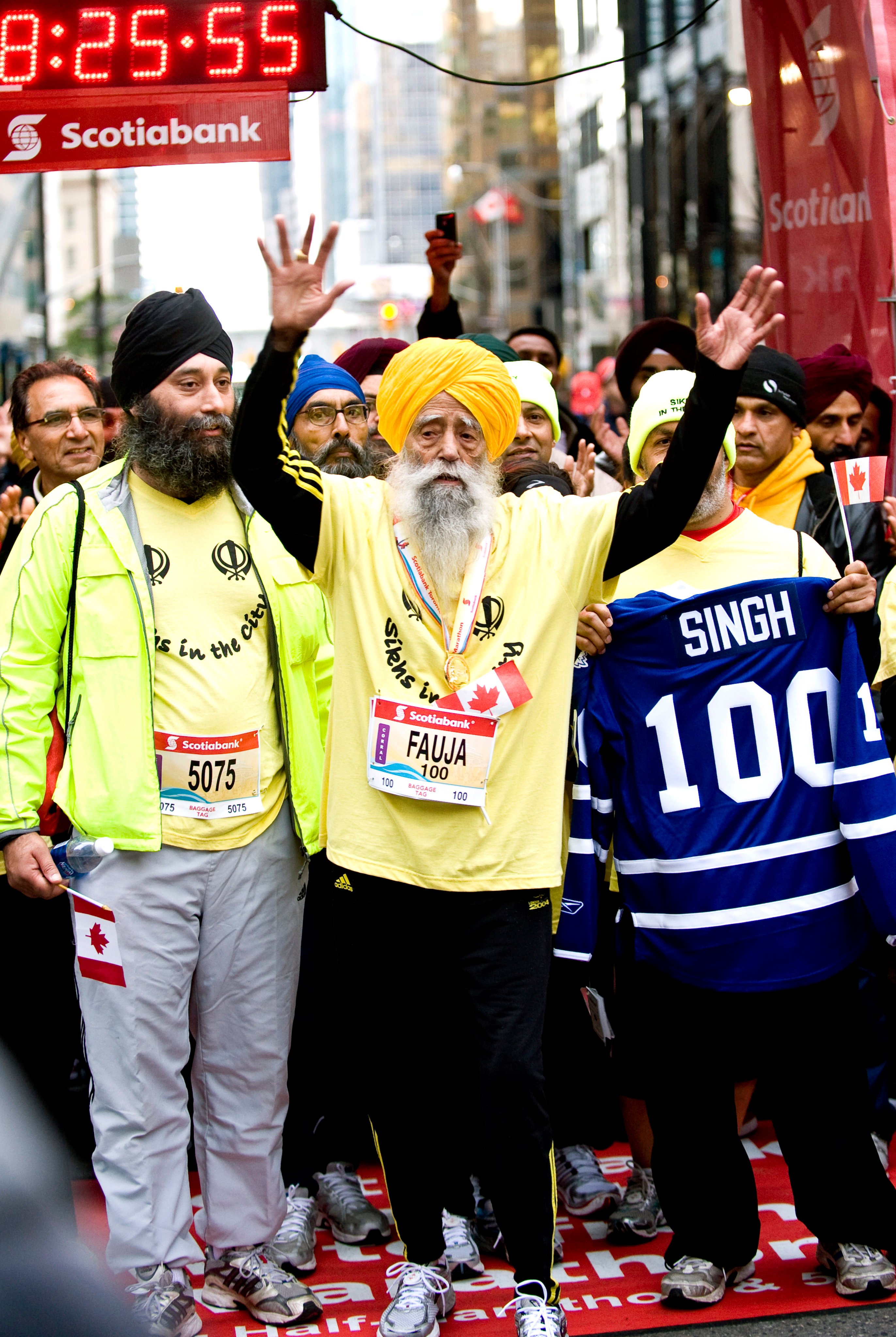 Fauja Singh (centre), then 100,  celebrates after completing the Toronto Waterfront Marathon in 2011. Photo: AP