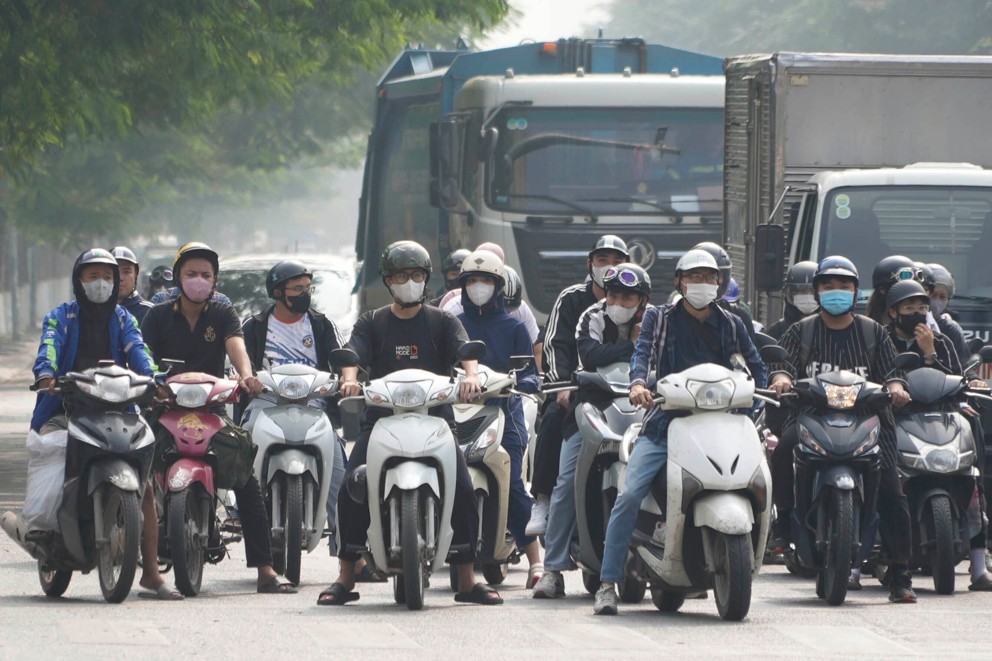 Motorcyclists wearing face masks wait at a traffic signal in Hanoi, Vietnam. Photo: AP
