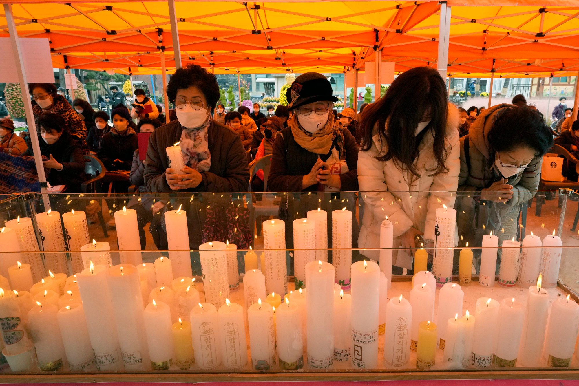 Parents pray to wish for their children’s success in the university entrance exam at a temple in Seoul. Photo: AP Parents pray to wish for their children’s success in the university entrance exam at a temple in Seoul. Photo: AP