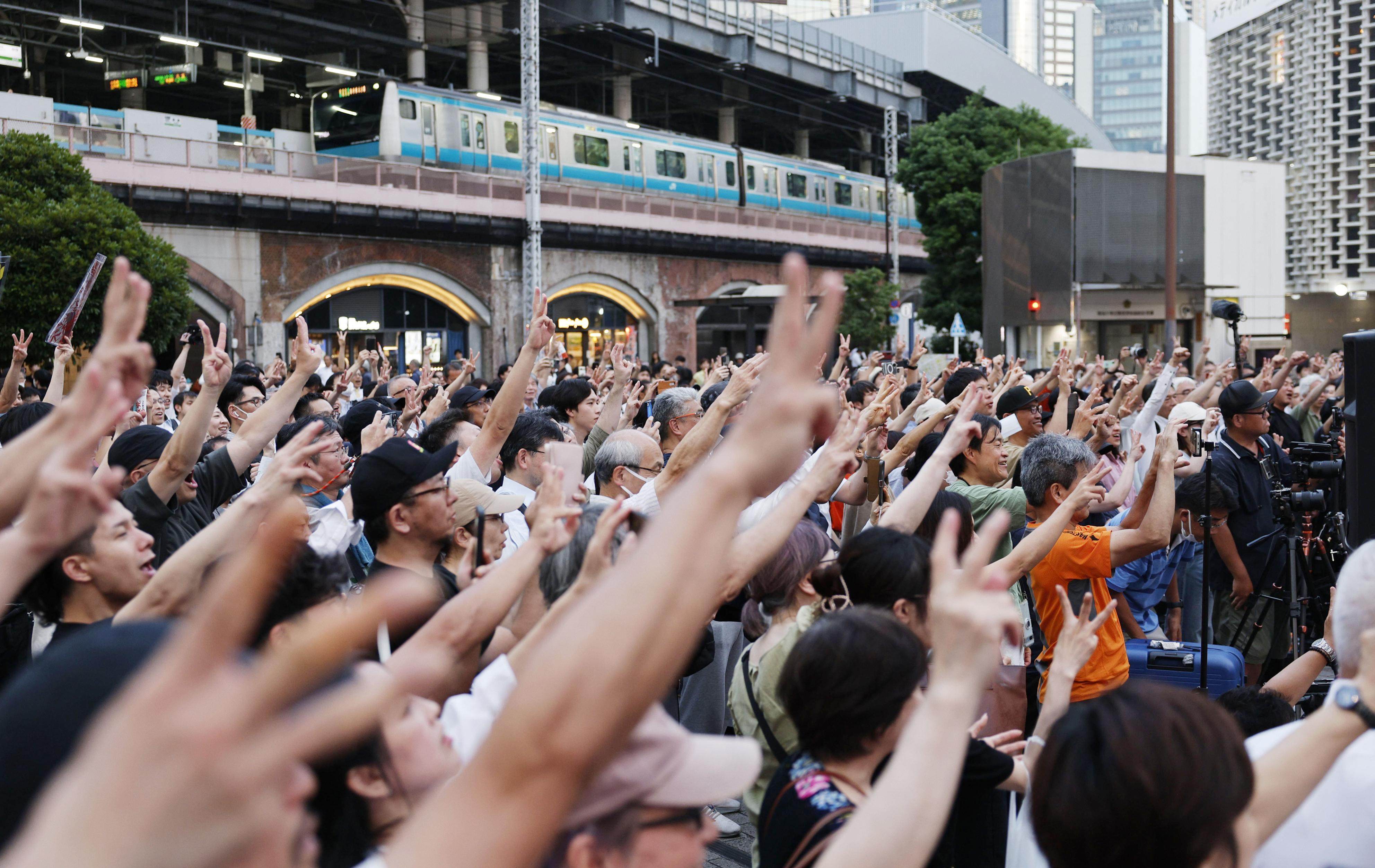 Voters listen to Sohei Kamiya, leader of the opposition Sanseito party in front of JR Shimbashi Station in Tokyo on July 3. Photo: Kyodo