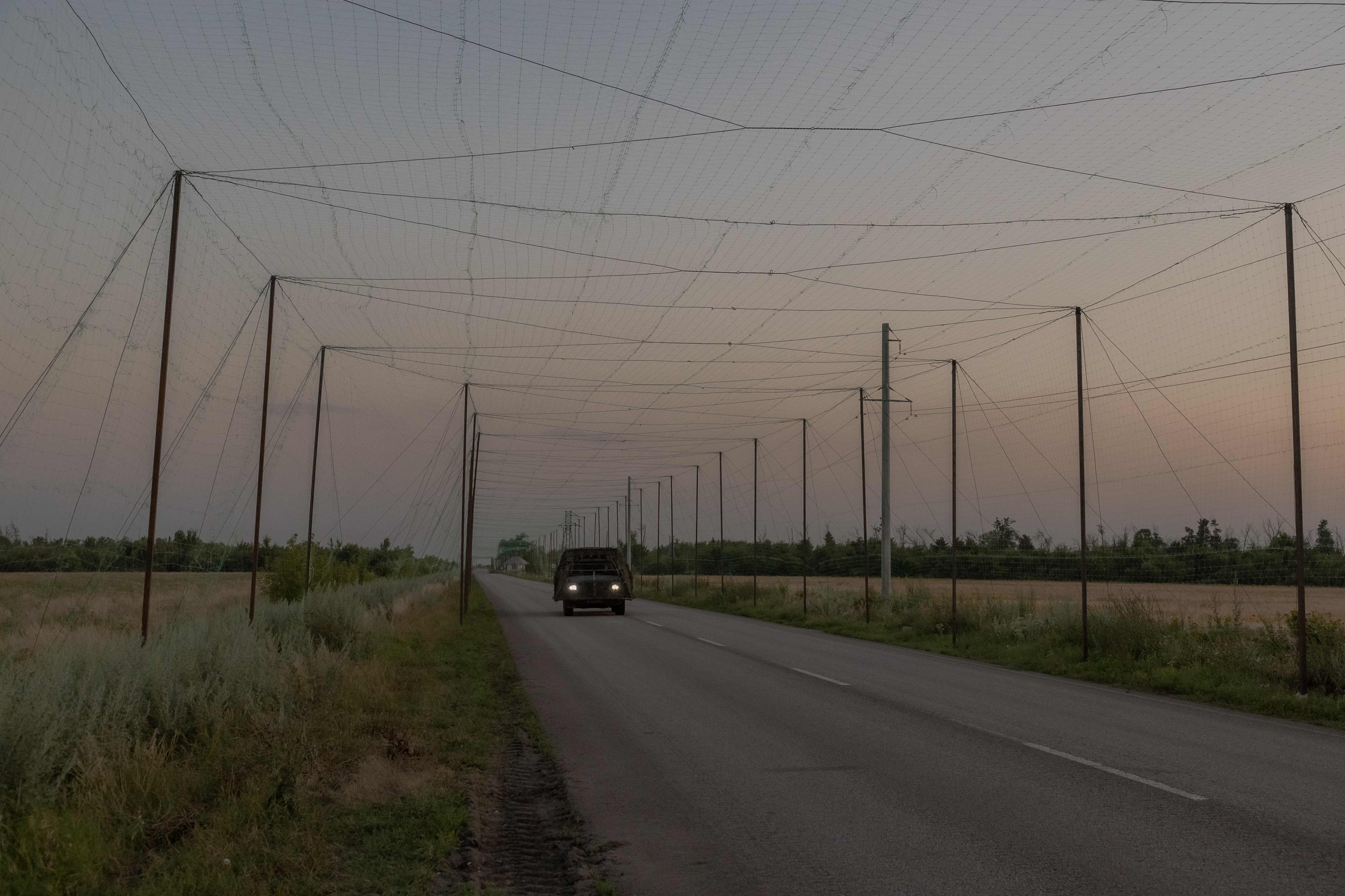 A military vehicle drives on a road under anti-drone nets in the eastern Donetsk region, Ukraine. Photo: AFP