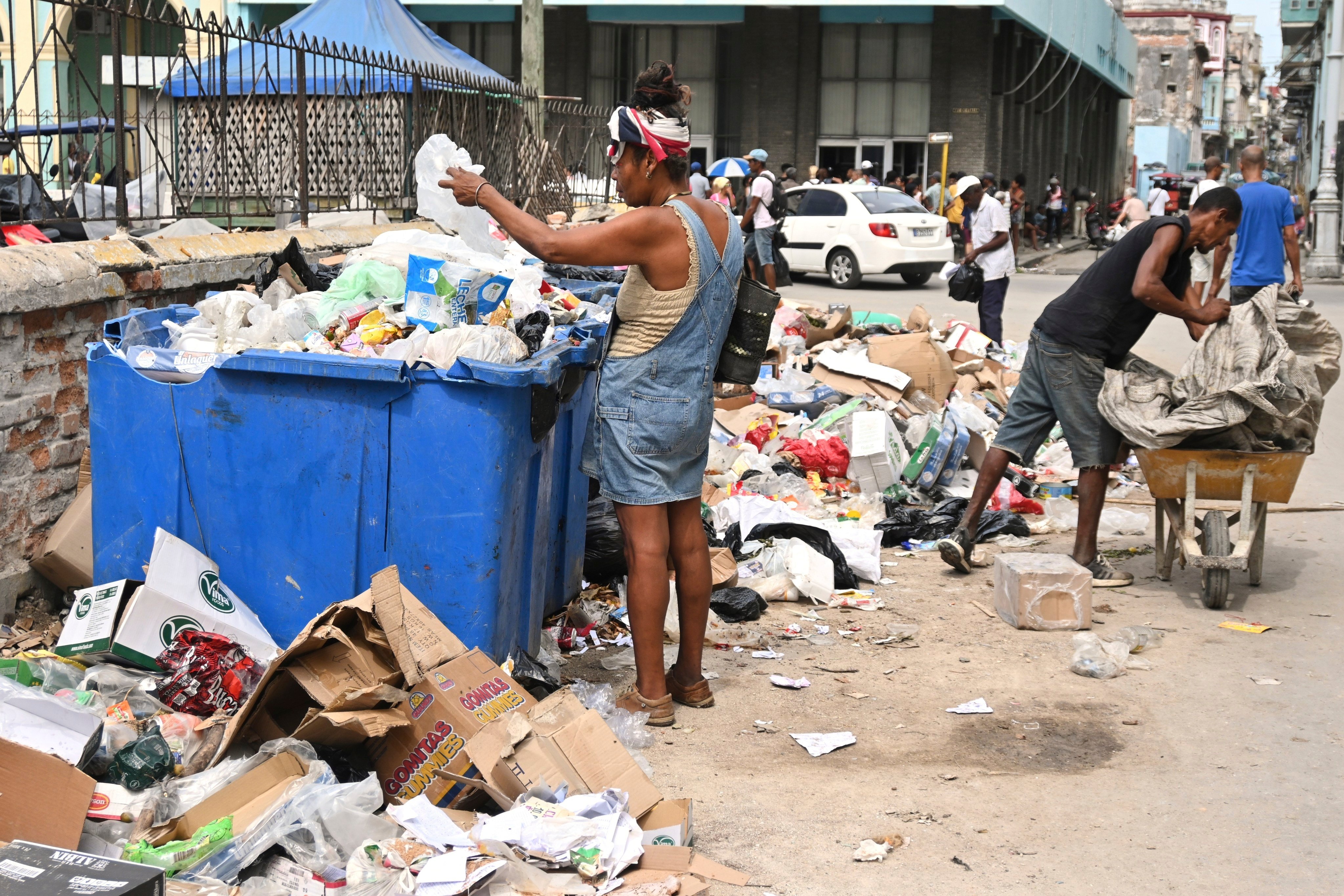 A woman  in Havana, Cuba. searches through a dumpster looking for useful items. Photo: AP