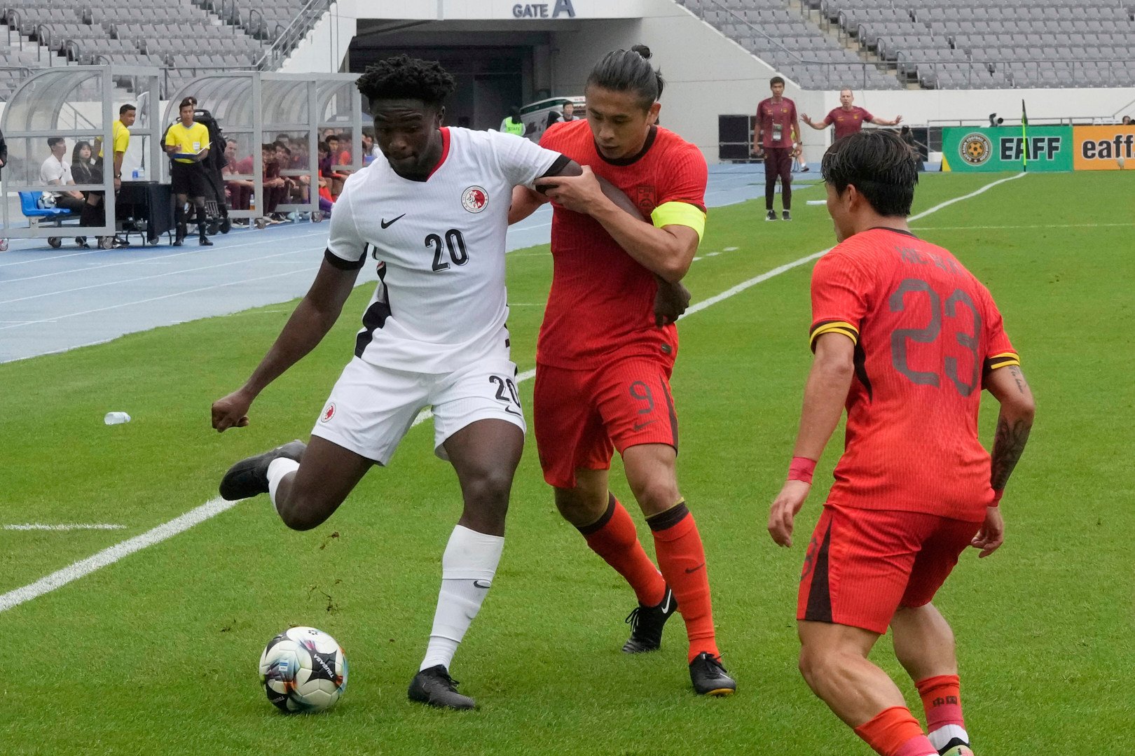 Michael Udebuluzor (left) fights for the ball during Hong Kong’s East Asian Championship clash with China. Photo: AP