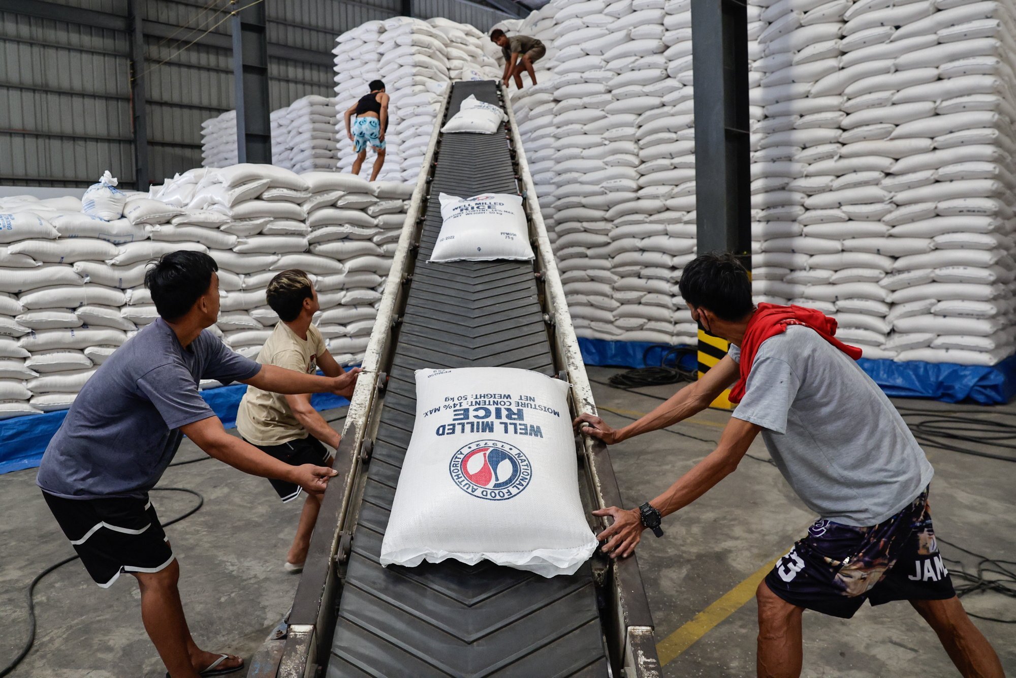 Workers move sacks of rice for transport from a National Food Authority warehouse in Metro Manila in February. The Philippines’ rice imports hit a record 4.7 million tonnes last year. Photo: EPA-EFE