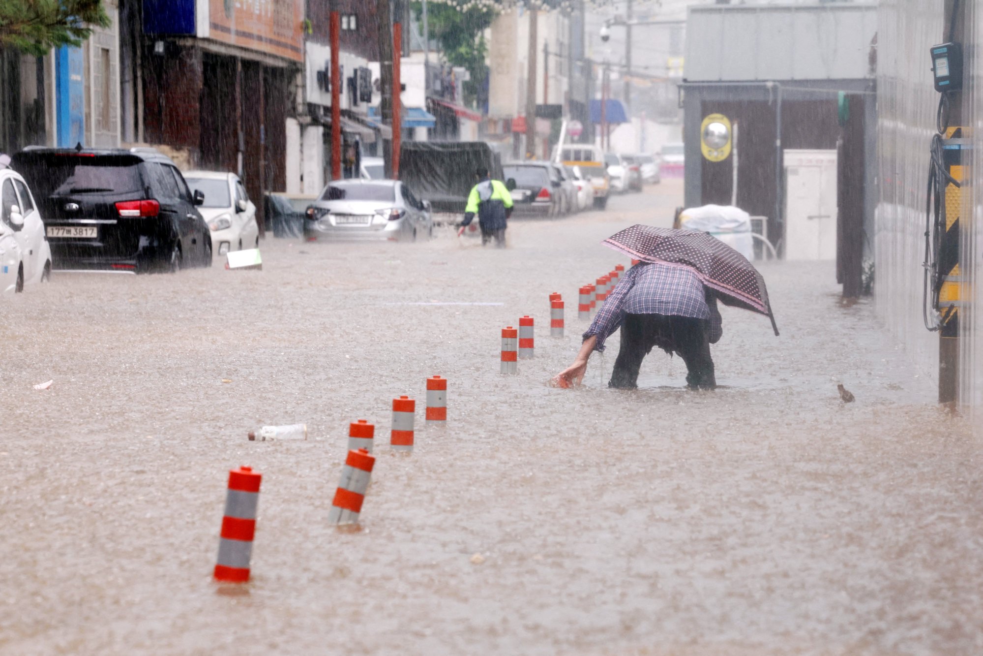 A man walks through a flooded street caused by torrential rain in Gwangju, South Korea, on Thursday. Photo: Yonhap via Reuters A man walks through a flooded street caused by torrential rain in Gwangju, South Korea, on Thursday. Photo: Yonhap via Reuters