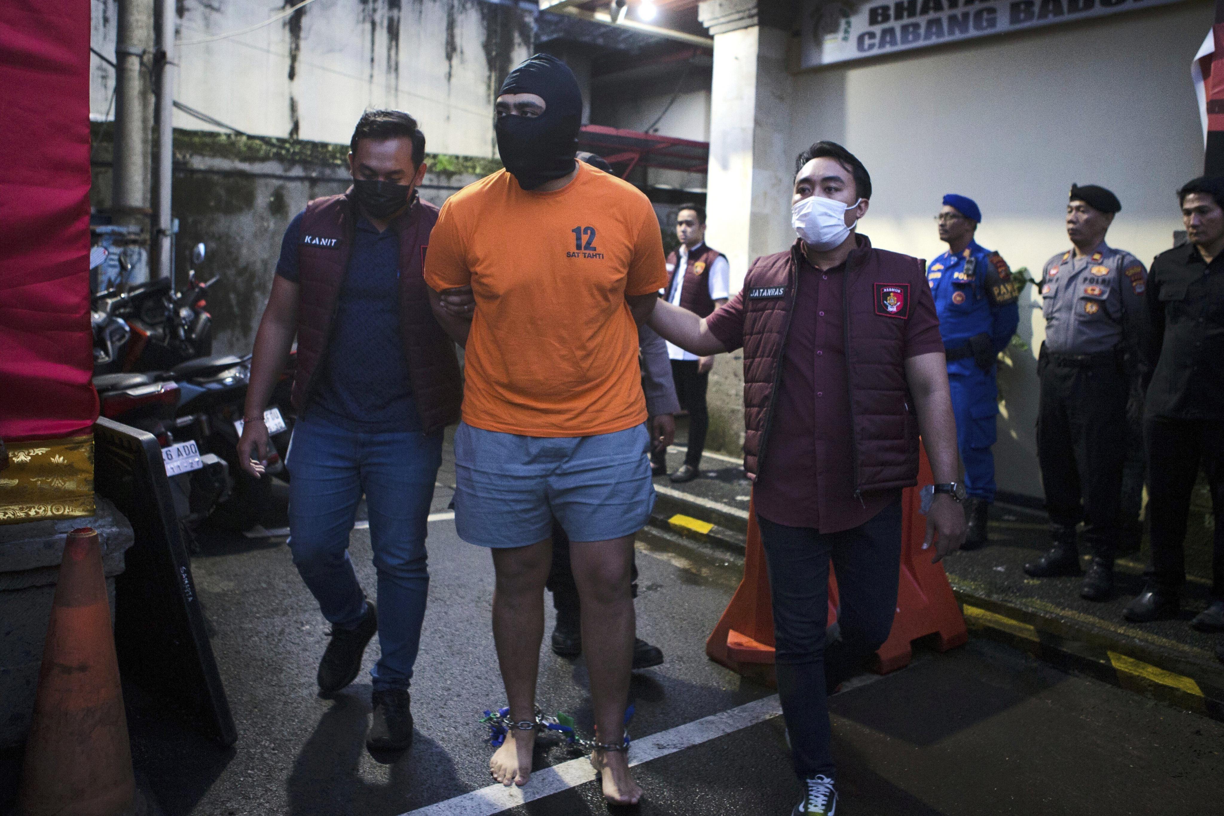 Indonesian police officers escort Australian M.C., one of the suspects in the fatal shooting of an Australian tourist, ahead of a press conference at the local police precinct in Badung, Bali, Indonesia on Thursday, June 26, 2025. Photo: AP