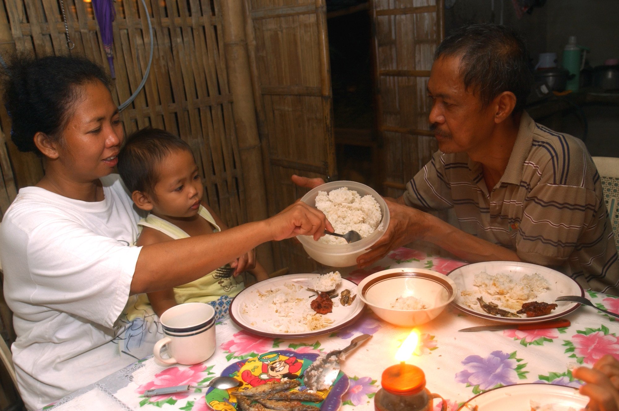 A family in the Philippines eats together, with rice as part of their meal. Photo: Ariel Javellana/IRRI