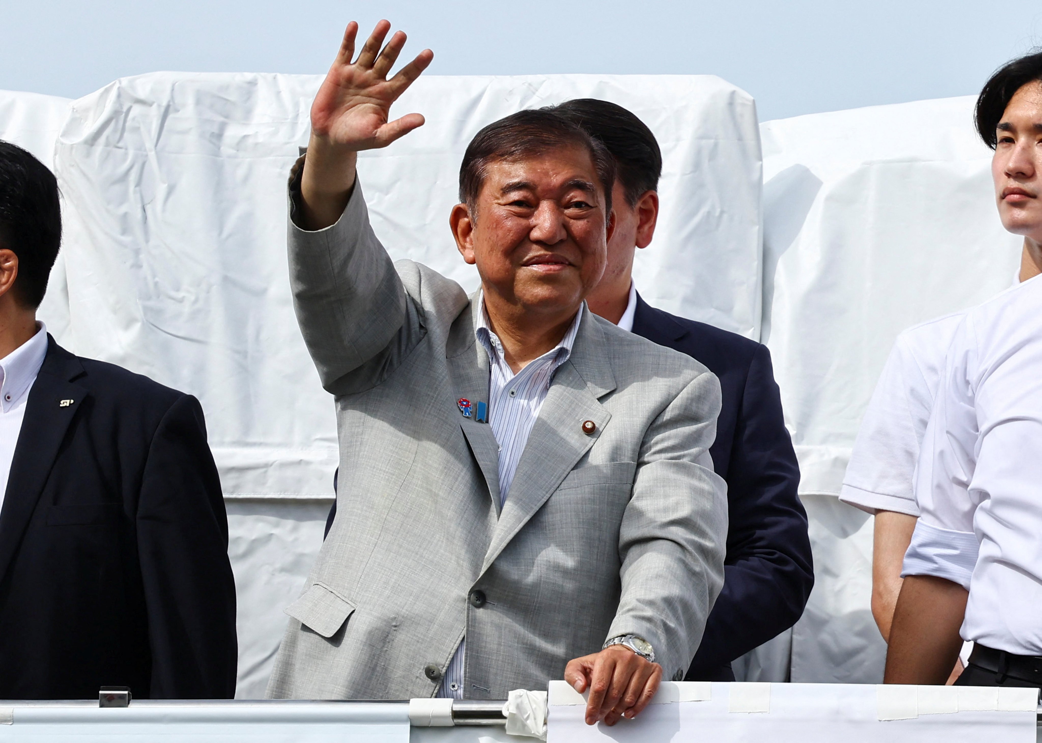 Japan’s Prime Minister Shigeru Ishiba, who is also the leader of the ruling Liberal Democratic Party, waves to voters from atop an election campaign van in Yokohama on Friday. Voters will head to the polls on Sunday for Japan’s upper house election. Photo: Reuters