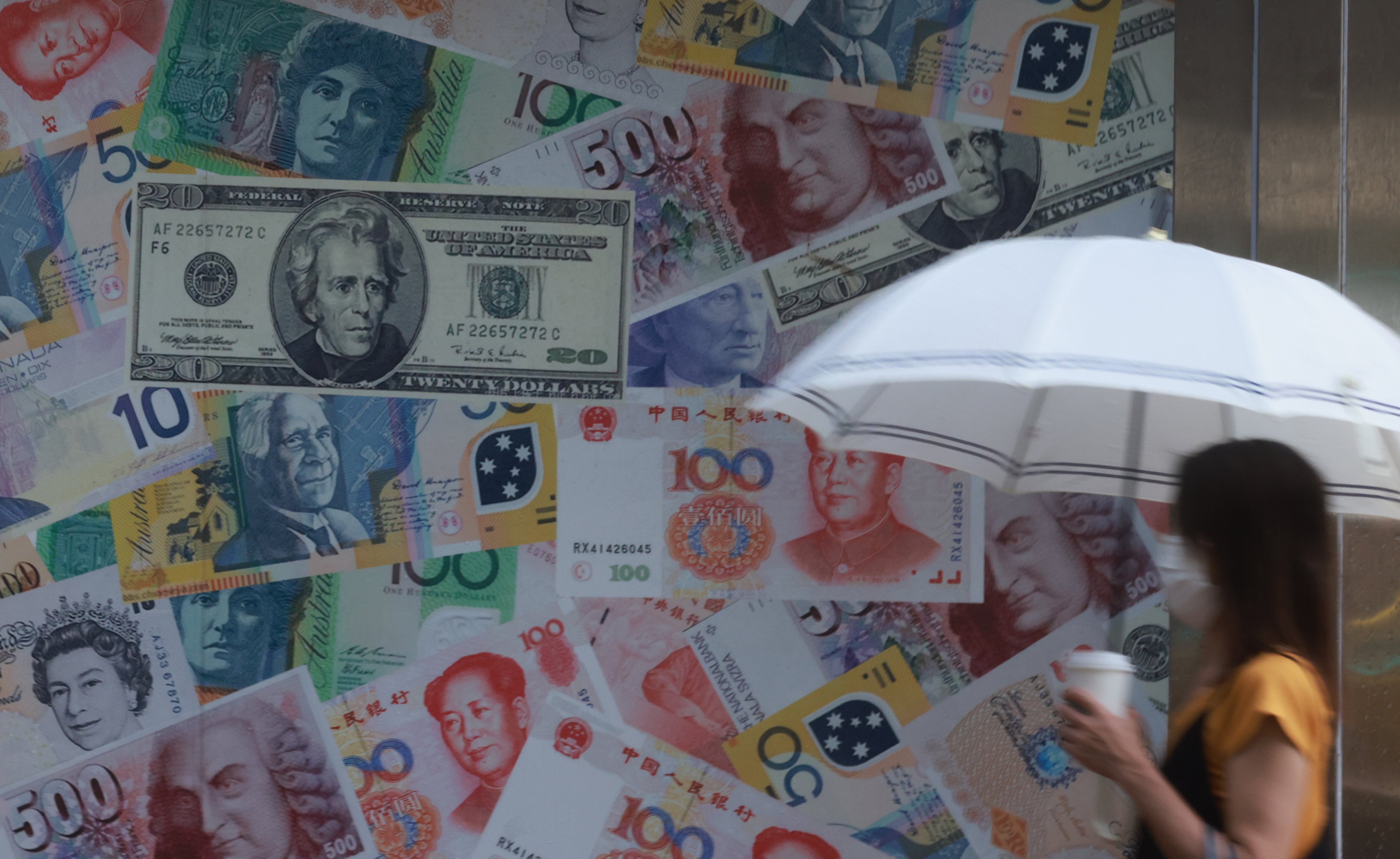 People walk past by a billboard showing foreign currencies in Sheung Wan. The Hong Kong dollar’s peg to the US dollar has been in place since October 1983 and survived every attempt to undermine or destabilise it so far. Photo: May Tse