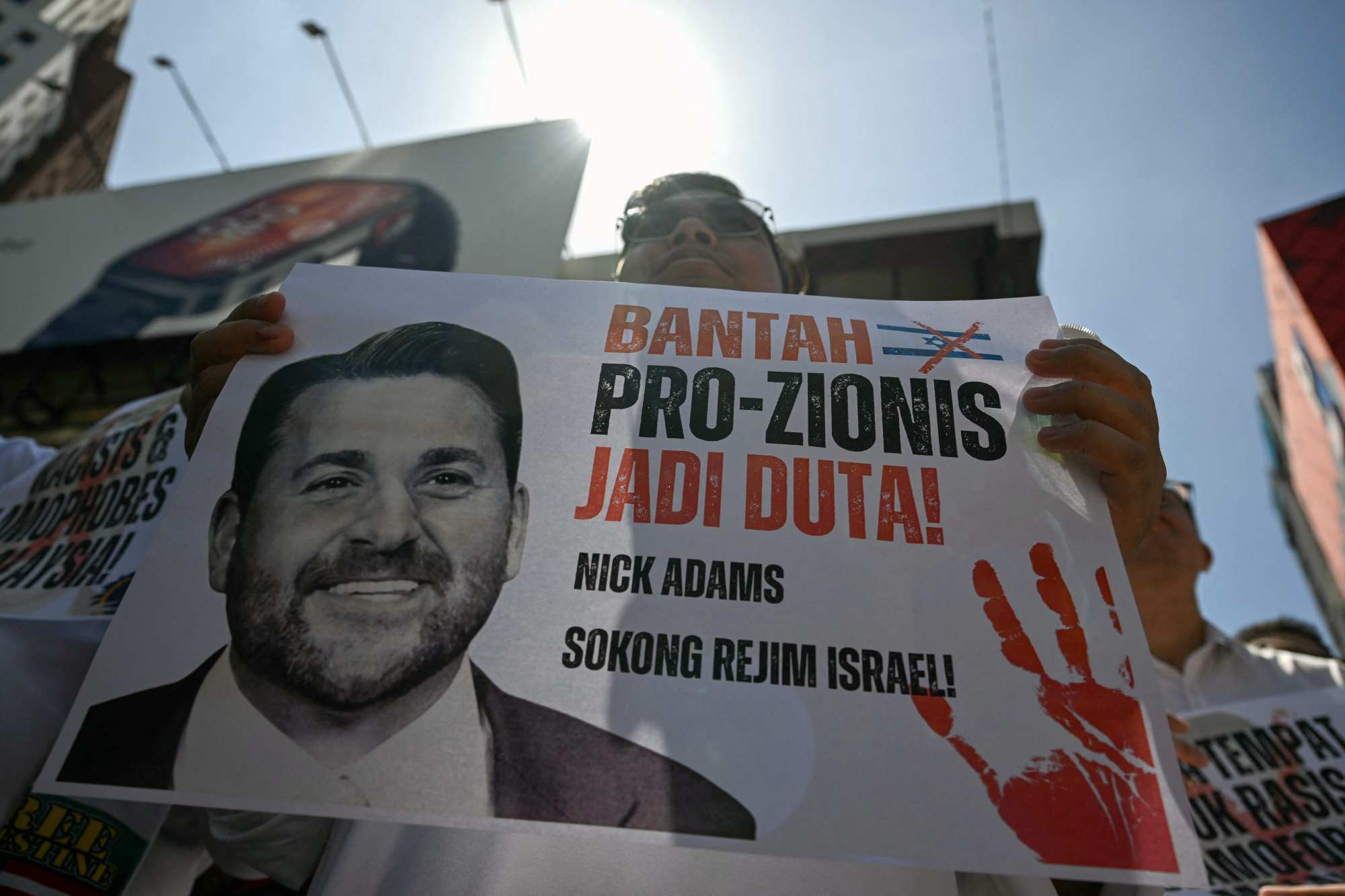 A protester holds up a placard during a demonstration against the US envoy nominee Nick Adams outside the US embassy in Kuala Lumpur on Friday. Photo: AFP