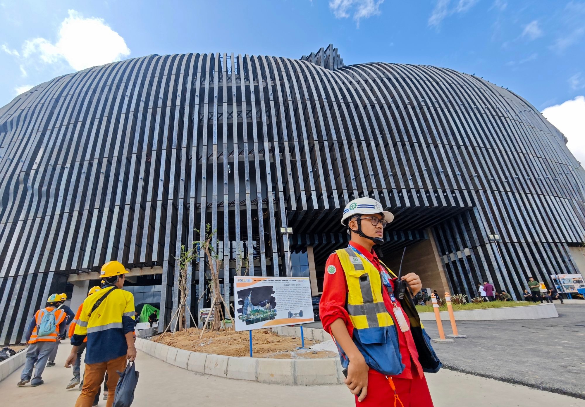Construction workers walk past a building under construction in Nusantara last year. Photo: EPA-EFE Construction workers walk past a building under construction in Nusantara last year. Photo: EPA-EFE