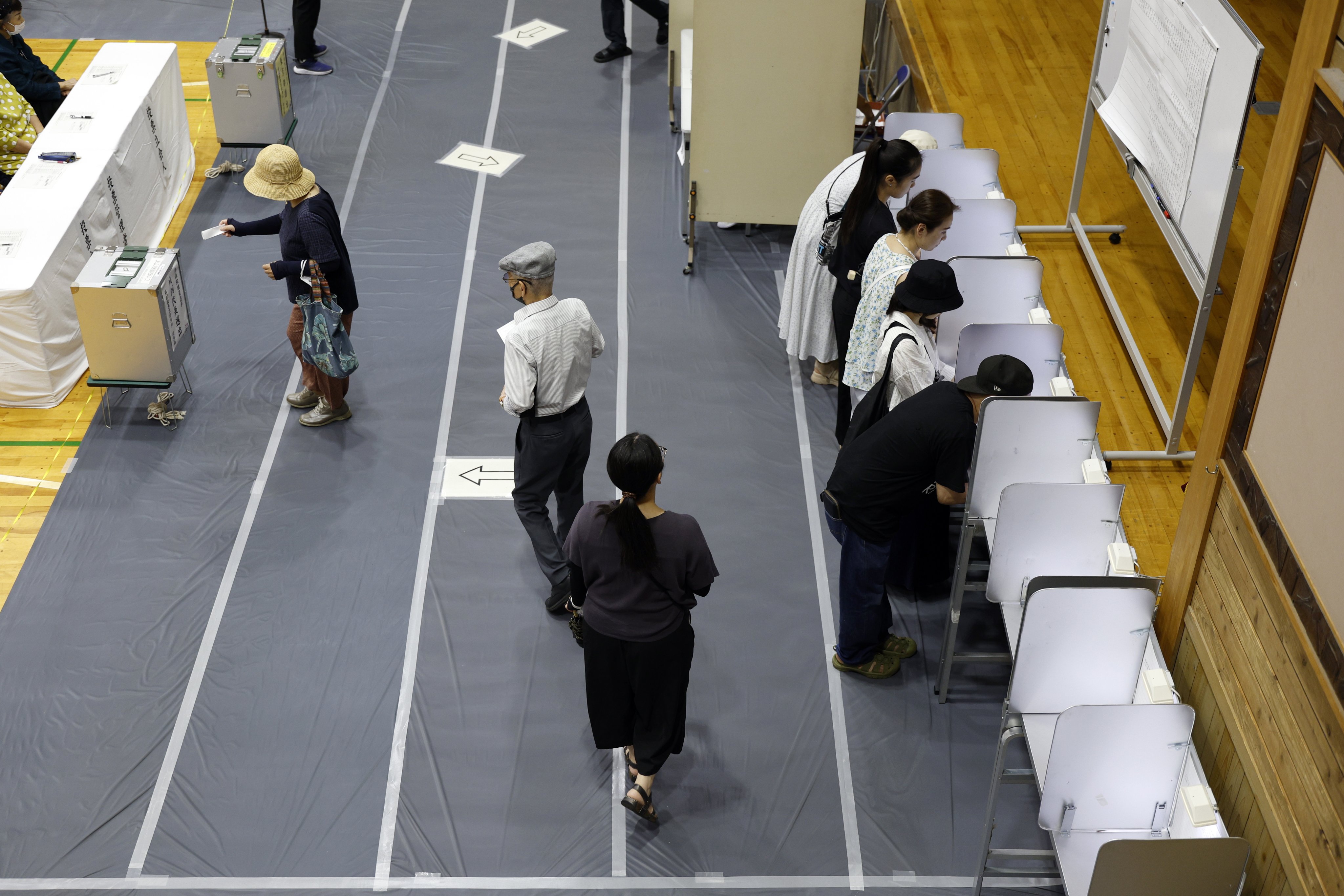 People vote in the upper house election at a polling station in Tokyo on Sunday. Photo: EPA