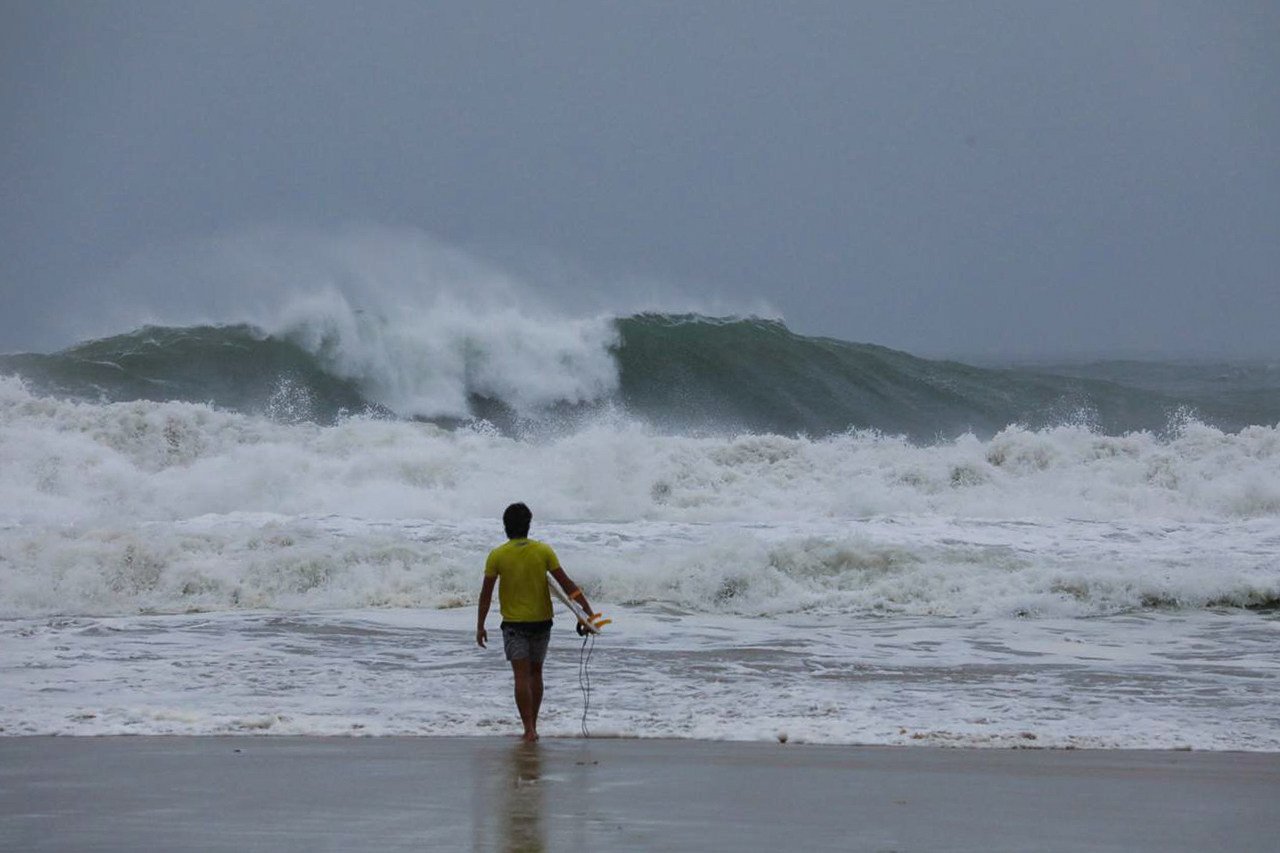 A man carrying a surfboard weighs up his options at Big Wave Bay as Typhoon Wipha approaches the city. He ultimately decided not to enter the water. Photo: Antony Dickson