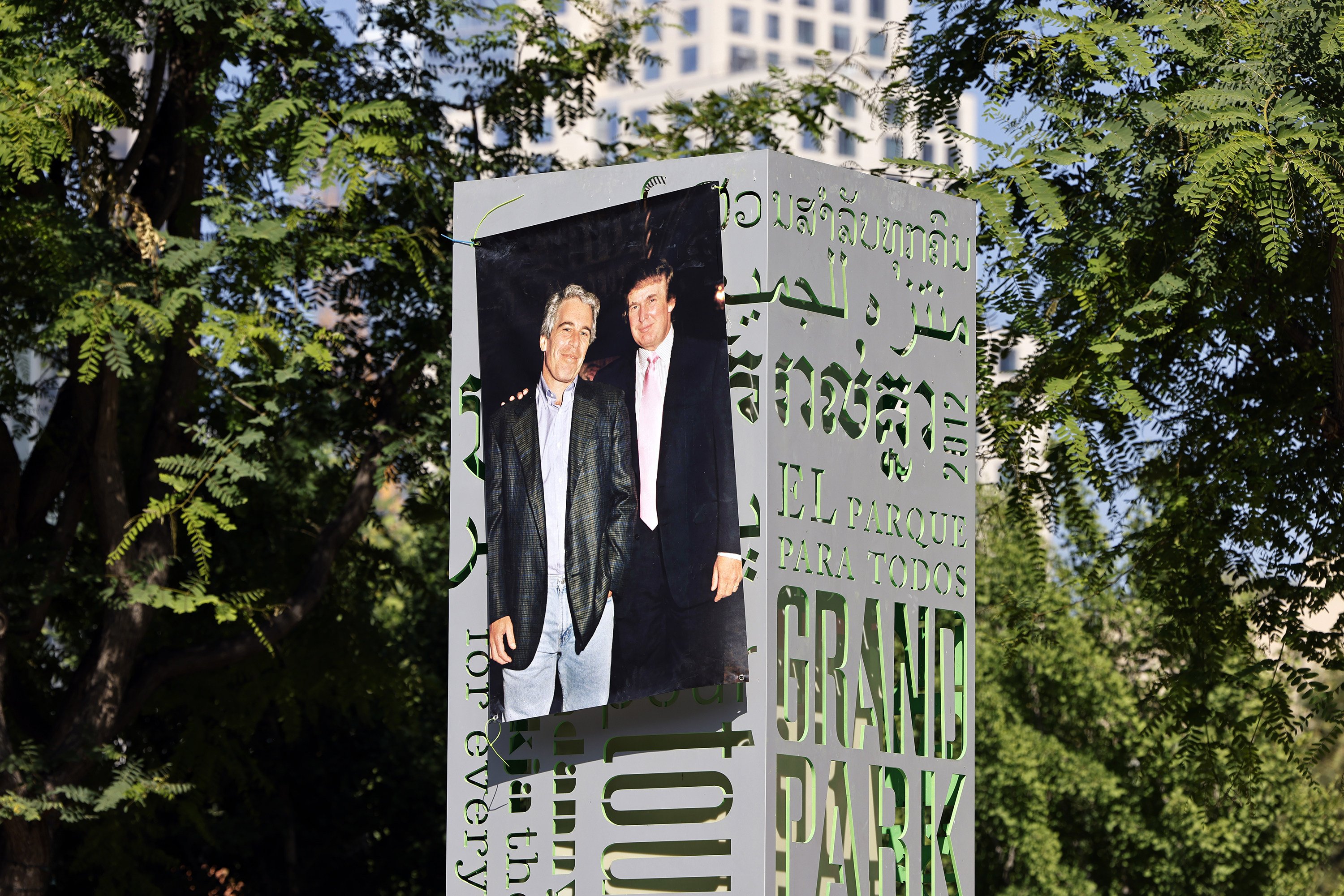 A 1997 photograph of Jeffrey Epstein (left) and Donald Trump hangs from a park sign in Los Angeles on June 15. Photo: Los Angeles Times/TNS