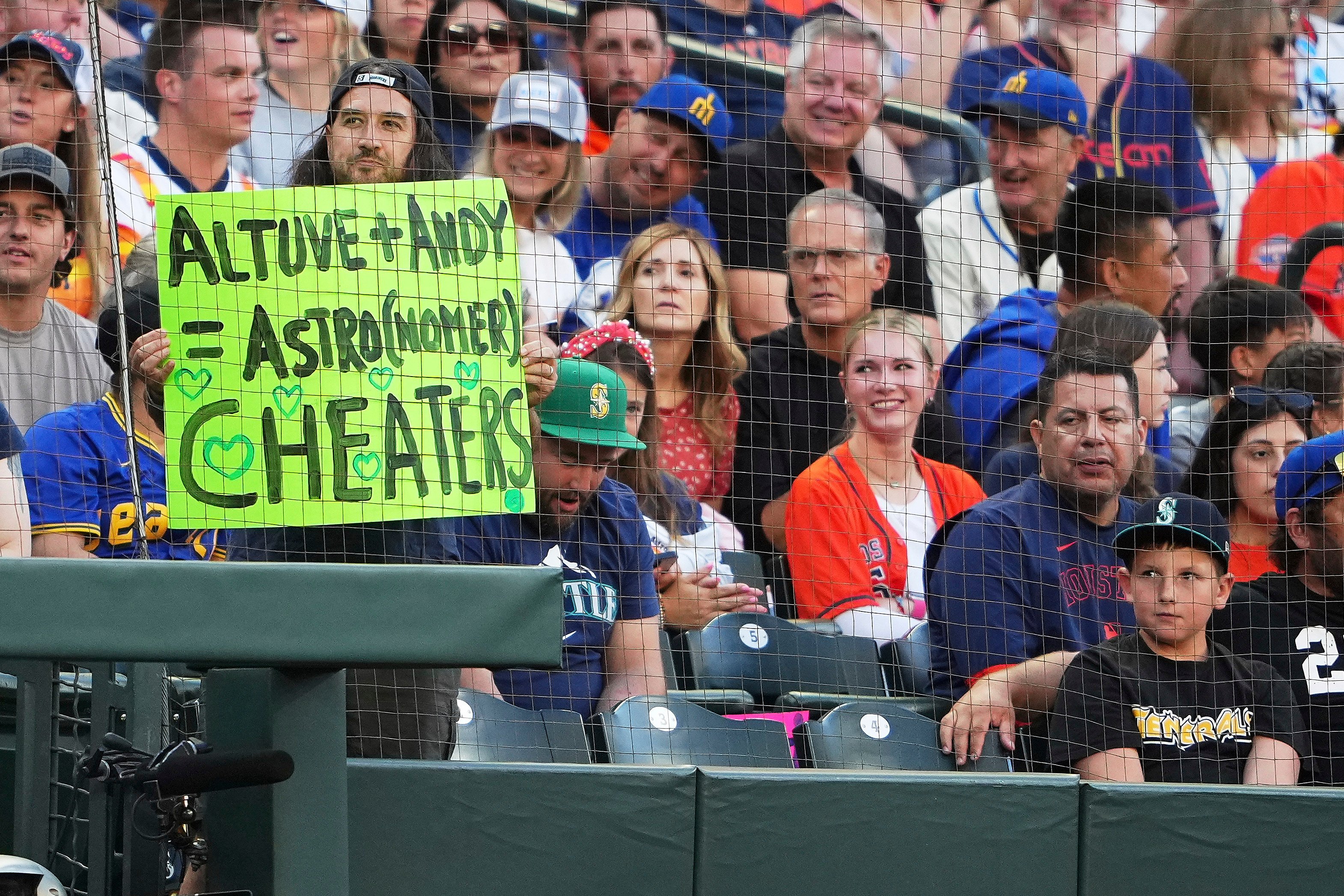 A fan holds up a sign as referencing Houston Astros’ Jose Altuve and Astronomer CEO Andy Byron as Altuve comes up to bat against the Seattle Mariners during the third inning of a baseball game in Seattle on Friday. Photo: AP