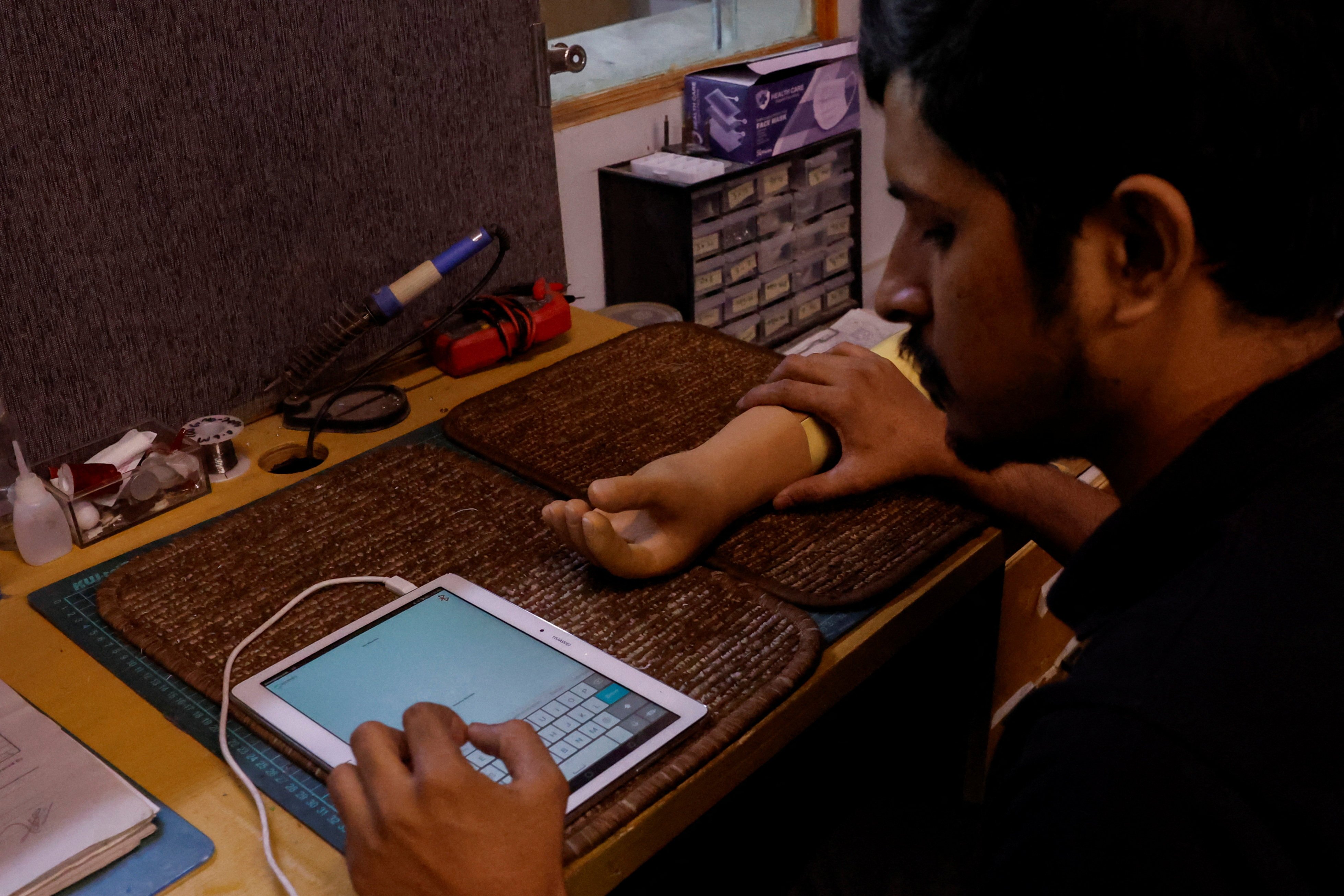 A Bioniks technician checks a prosthetic limb in Karachi, Pakistan. Photo: Reuters