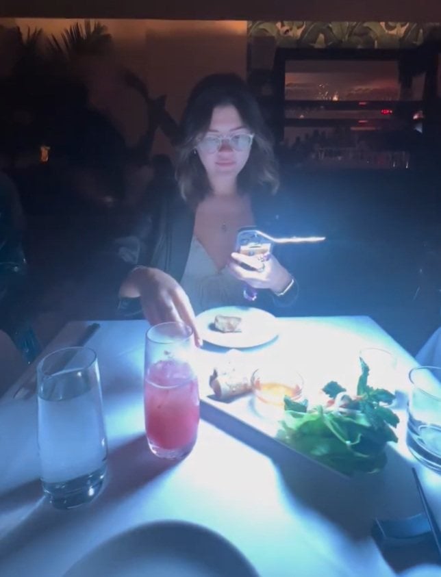 A food influencer is seen using an LED light to take photos and video in a restaurant, moments before the purported owner approaches her, in a still from an Instagram reel. Photo: Instagram/tooomuchfoood