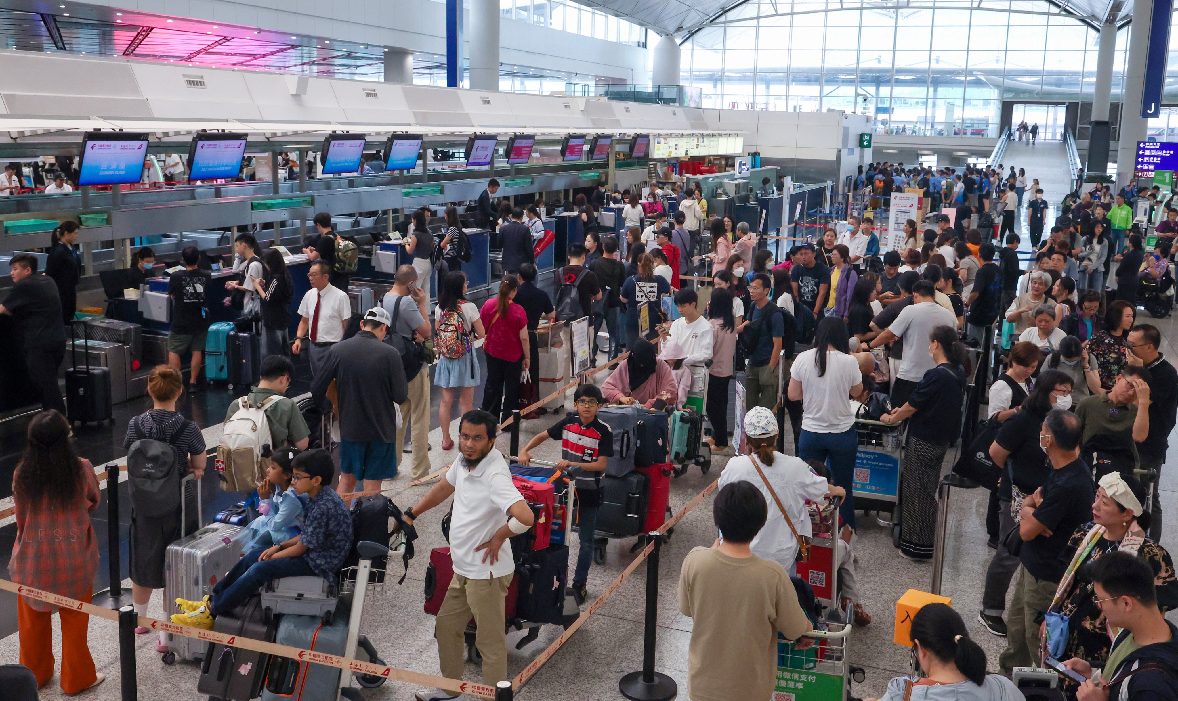 Passengers pack check-up areas as the airport clears a backlog of flights. Photo: Dickson Lee