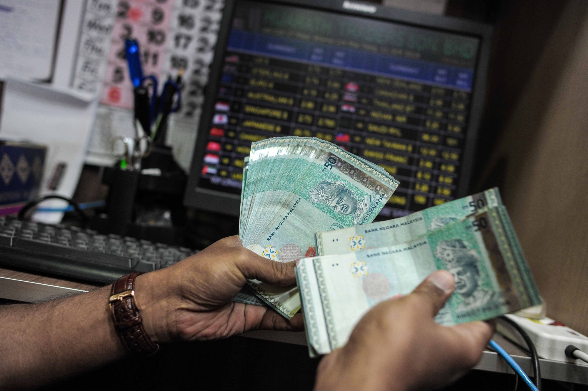 A money changer counts Malaysian ringgit banknotes in Kuala Lumpur. Malaysia’s new cash handout is expected to reach around 22 million people. Photo: AFP A money changer counts Malaysian ringgit banknotes in Kuala Lumpur. Malaysia’s new cash handout is expected to reach around 22 million people. Photo: AFP