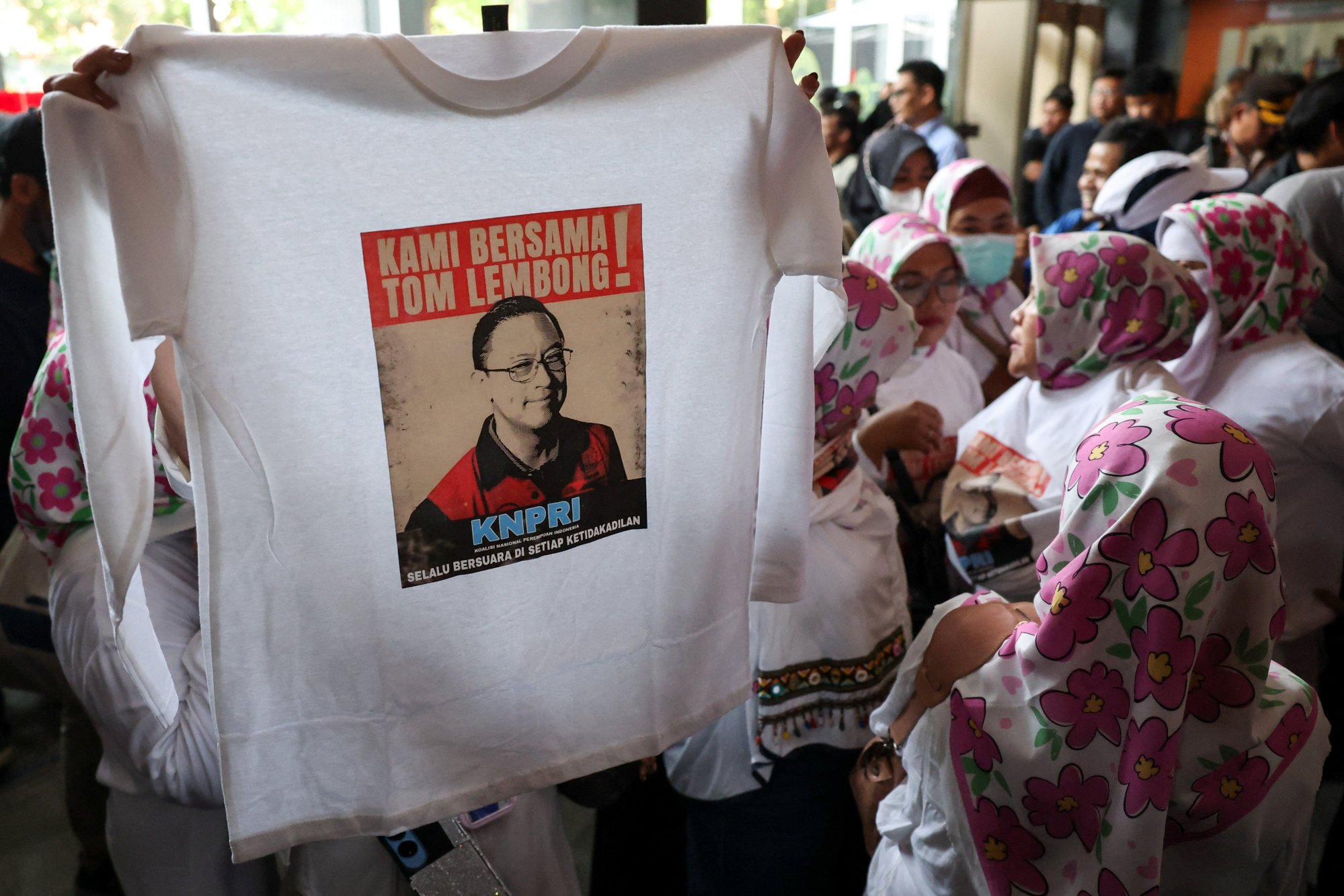 A supporter of Thomas Trikasih Lembong rises a long-sleeved T-shirt that reads “We are with Tom Lembong” at the Central Jakarta Court Indonesia, on July 18. Photo: Reuters