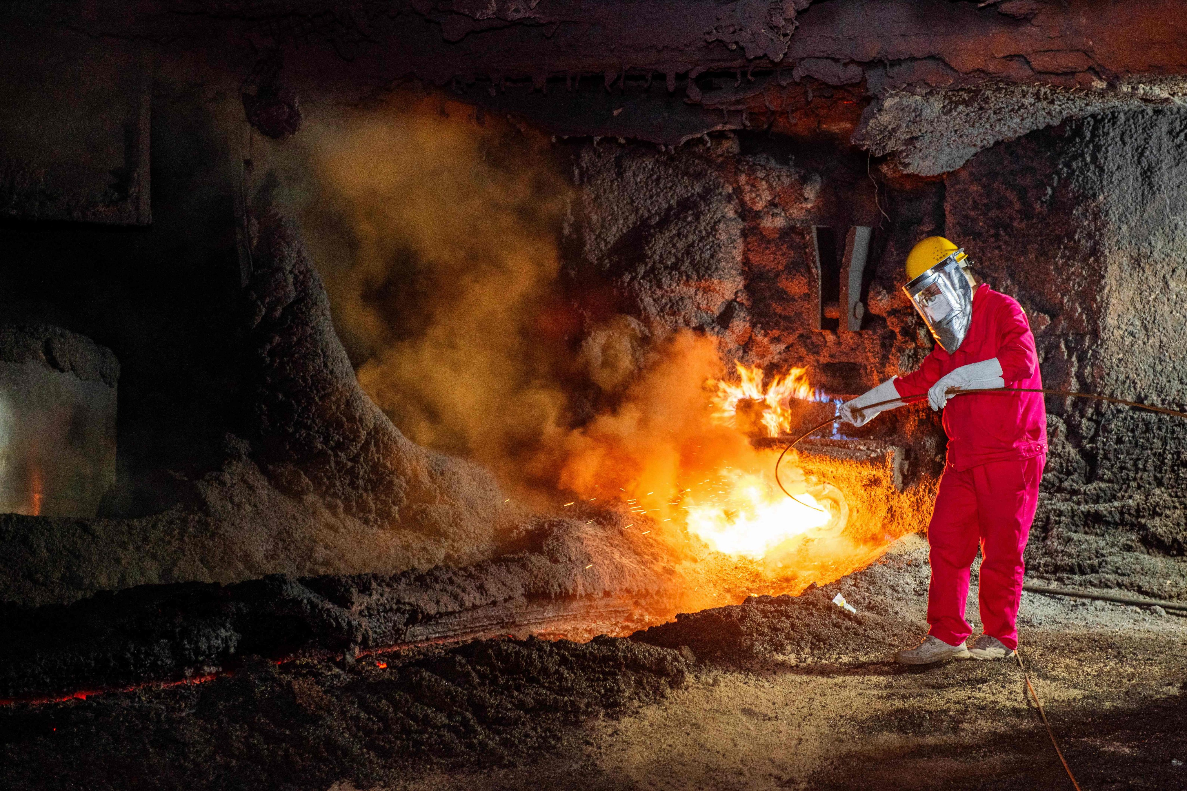 A worker stands by a stream of molten steel at a steel factory in Huaian, in eastern Jiangsu province, on July 22. Photo: AFP