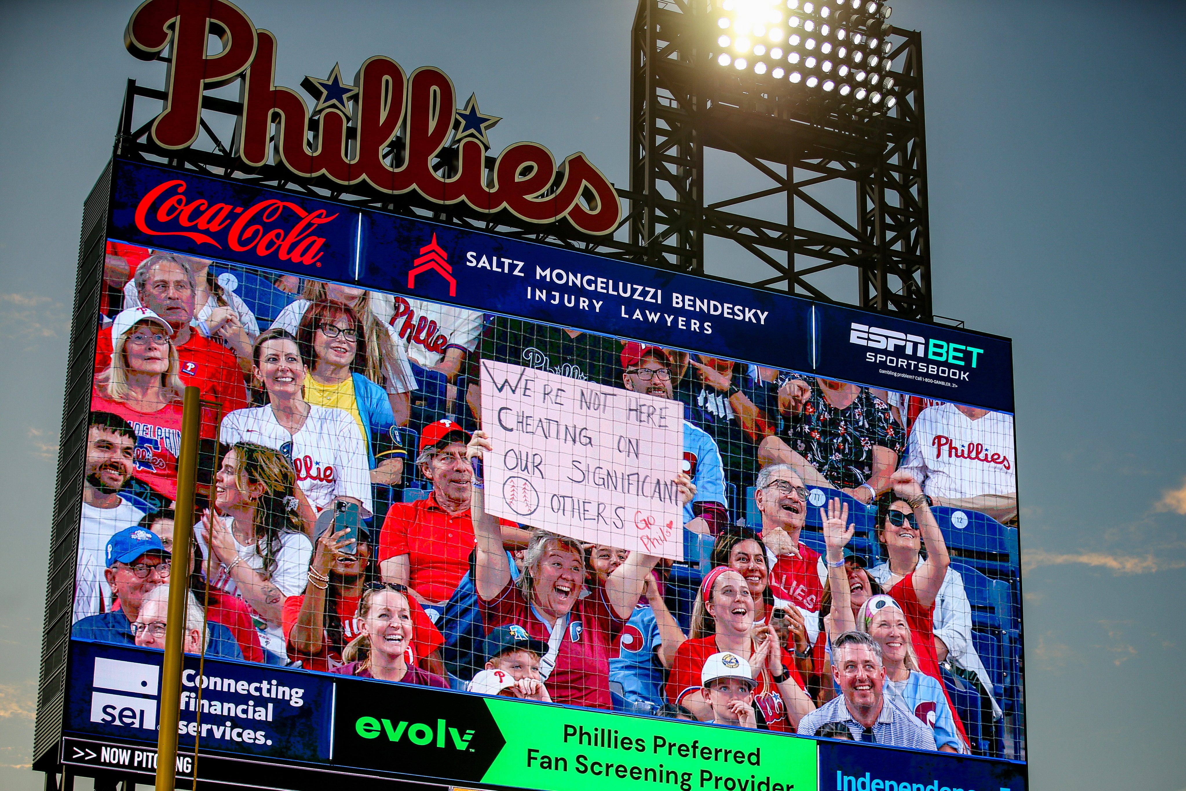 A fan holds up a sign reading “We’re not here cheating on our significant others” during a kiss cam segment of the baseball game between the Philadelphia Phillies and the Los Angeles Angels in Philadelphia, Pennsylvania. Photo: Getty Images